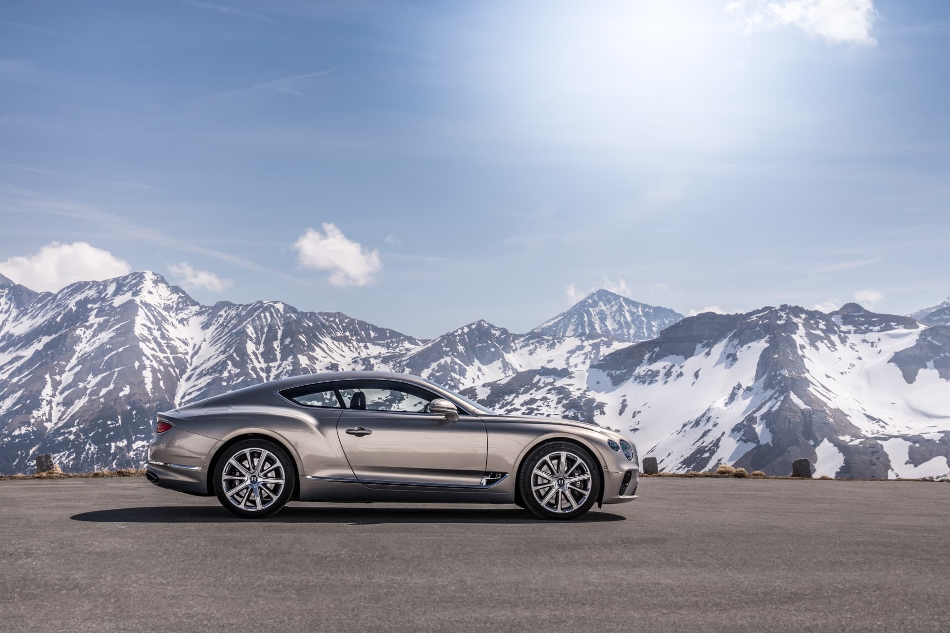 Perfil impecable del Bentley Continental GT con paisaje montañoso.