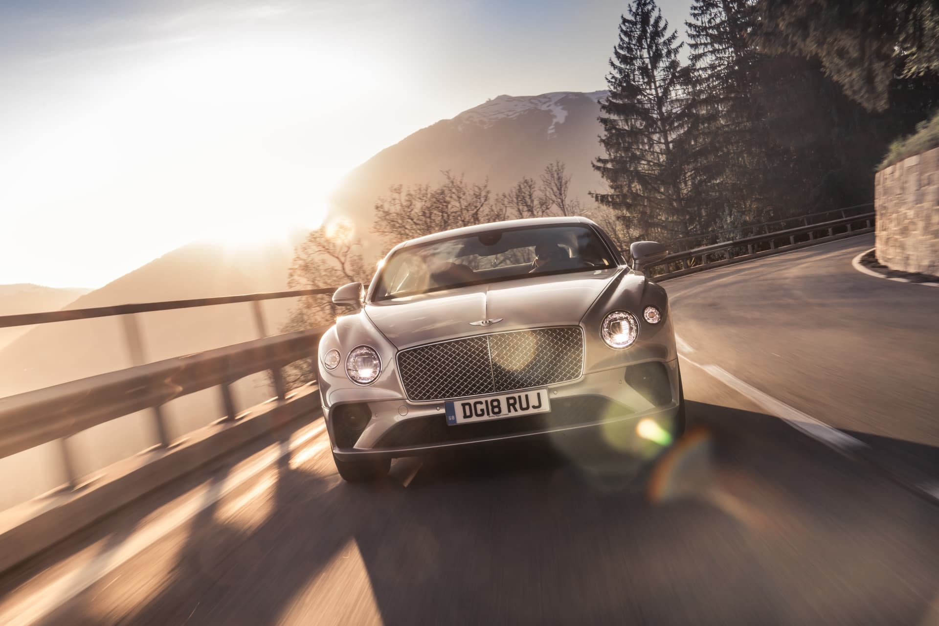 Vista frontal baja del Bentley Continental GT, integrado en la naturaleza.