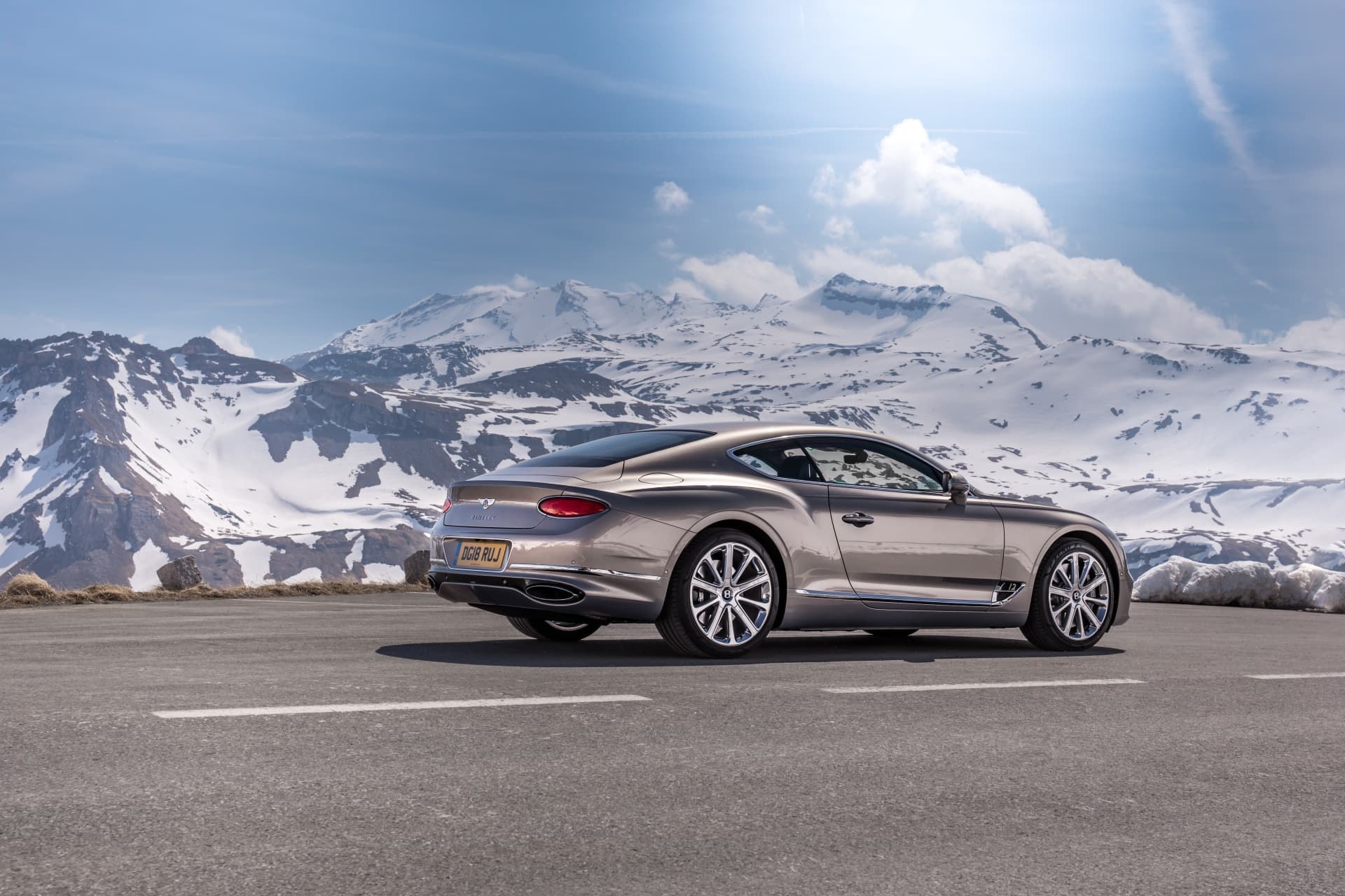 Mirada al Bentley Continental GT desde la trasera con montañas al fondo.