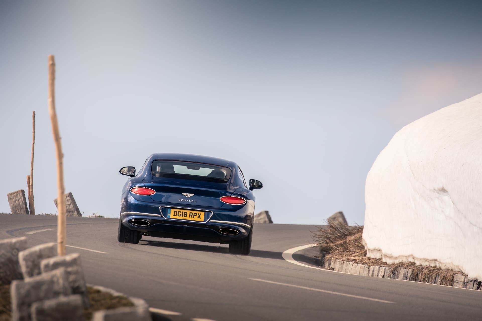 Bentley Continental GT tomando una curva, vista trasera.