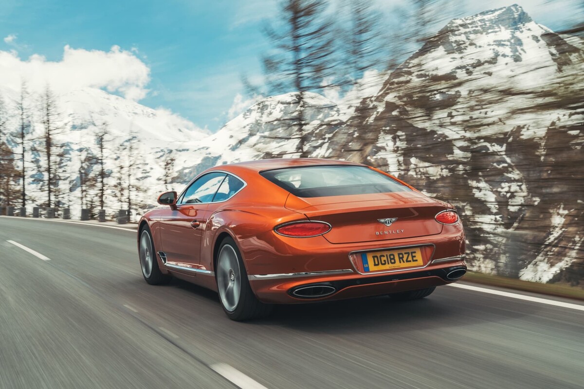 Fotografía aérea del Bentley Continental GT, destacando su lateral mientras navega por la carretera serpenteante. Fotografía aérea del Bentley Continental GT, destacando su lateral mientras navega por la carretera serpenteante.