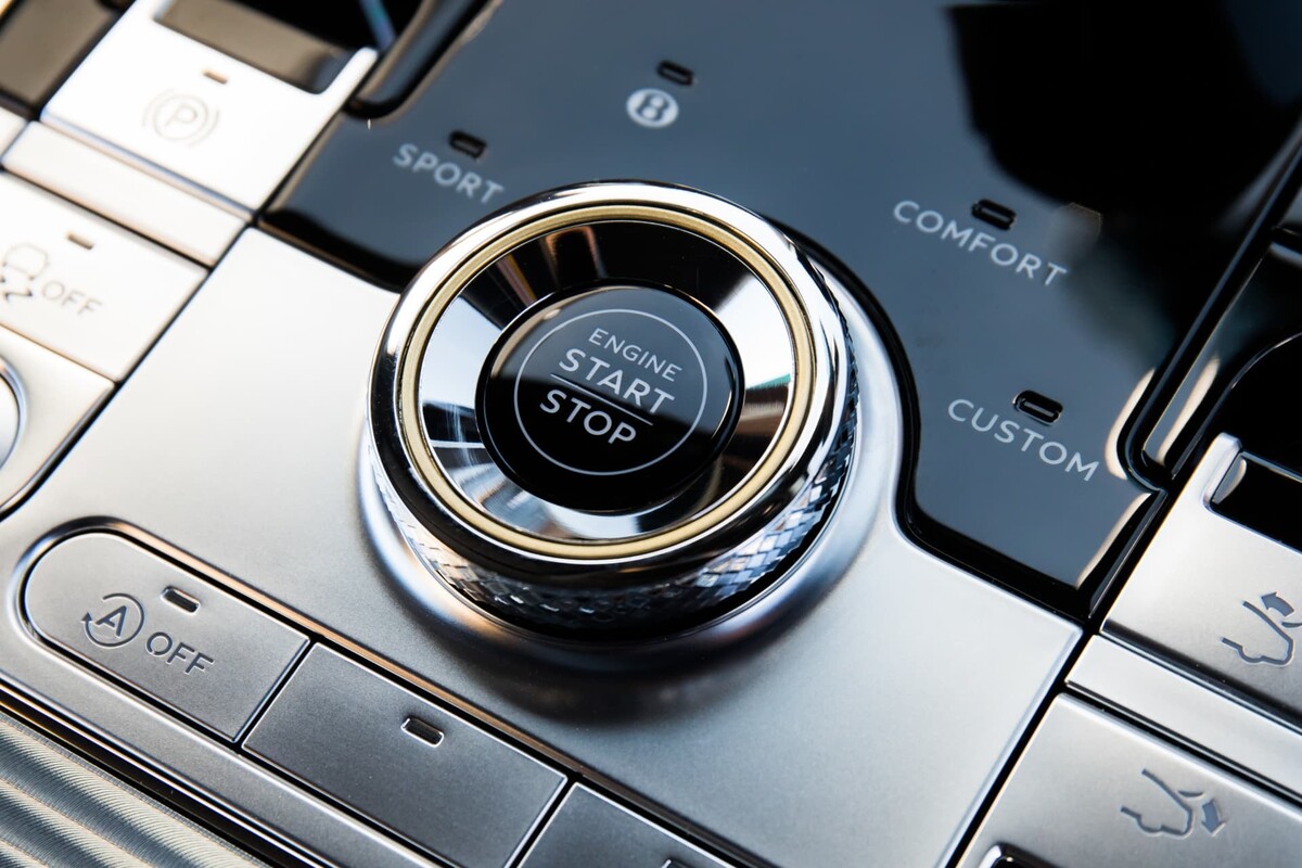 Vista del botón Start/Stop del Bentley Continental GT, rodeado de acabados de lujo. Vista del botón Start/Stop del Bentley Continental GT, rodeado de acabados de lujo.