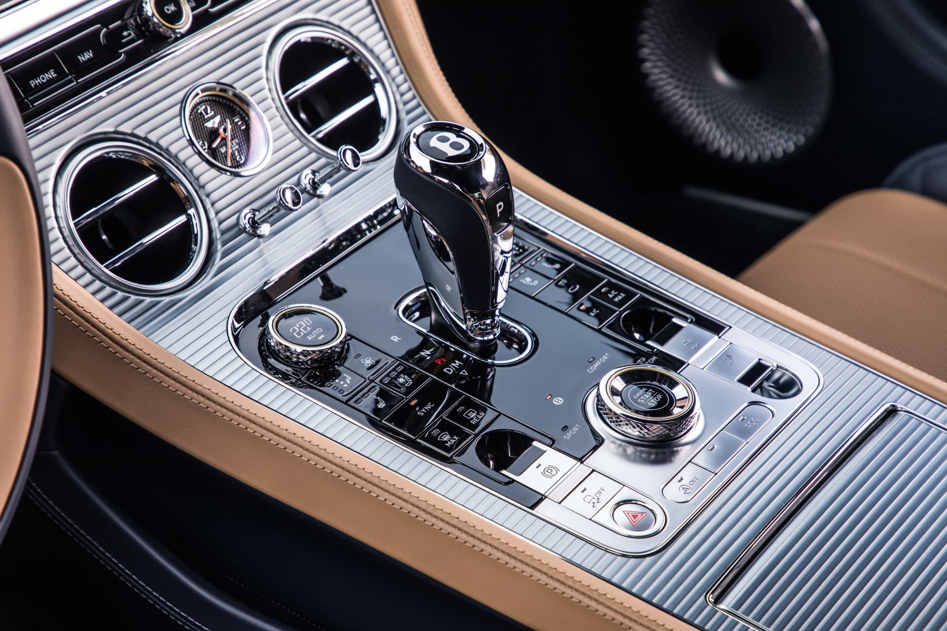Imagen nítida de la consola central del Bentley, con detalles en cromo y madera.