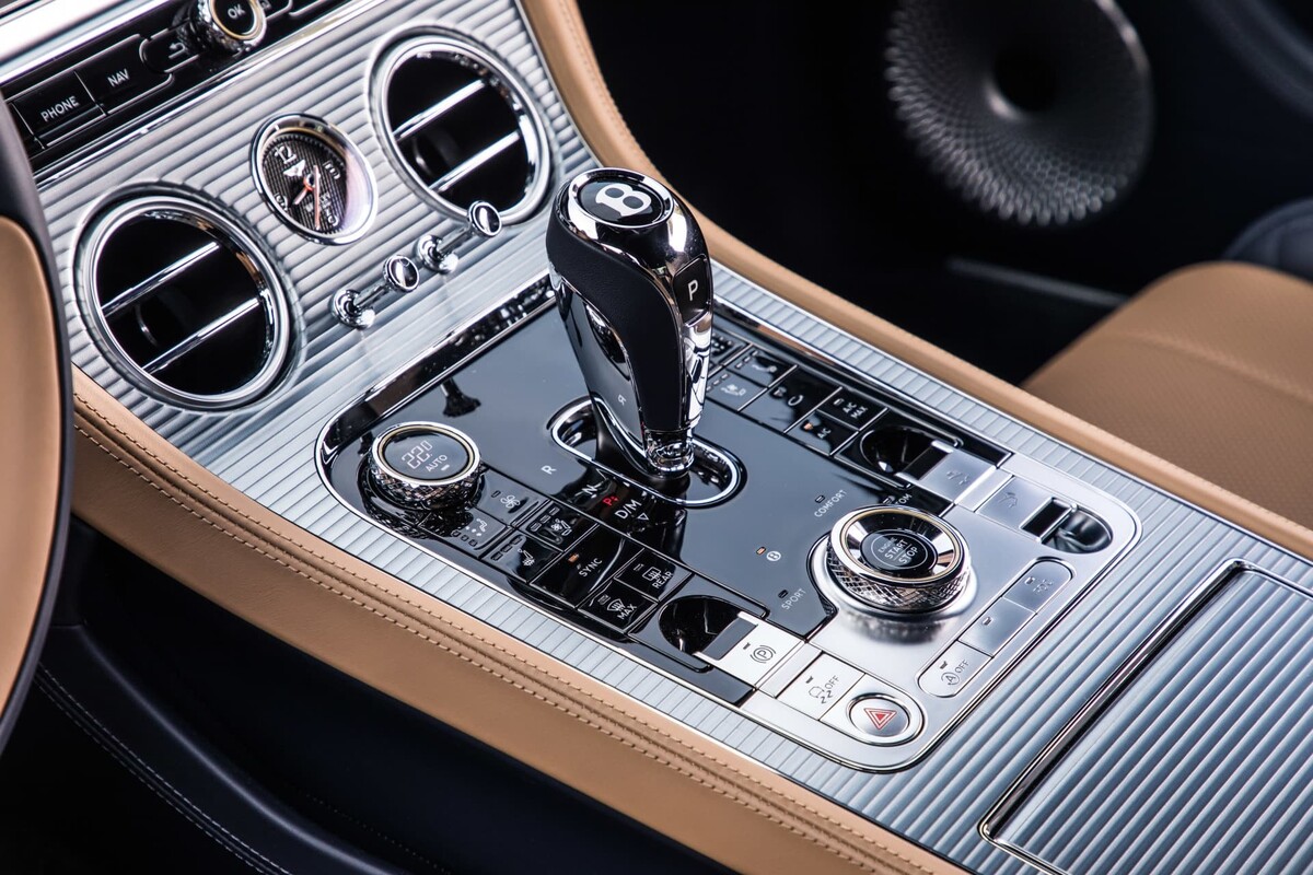 Imagen nítida de la consola central del Bentley, con detalles en cromo y madera. Imagen nítida de la consola central del Bentley, con detalles en cromo y madera.