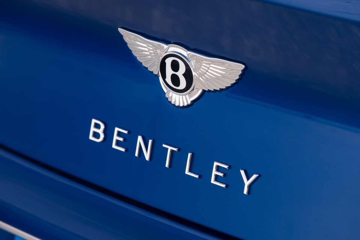 Imagen cercana del emblema de Bentley en la parte trasera del vehículo. Imagen cercana del emblema de Bentley en la parte trasera del vehículo.