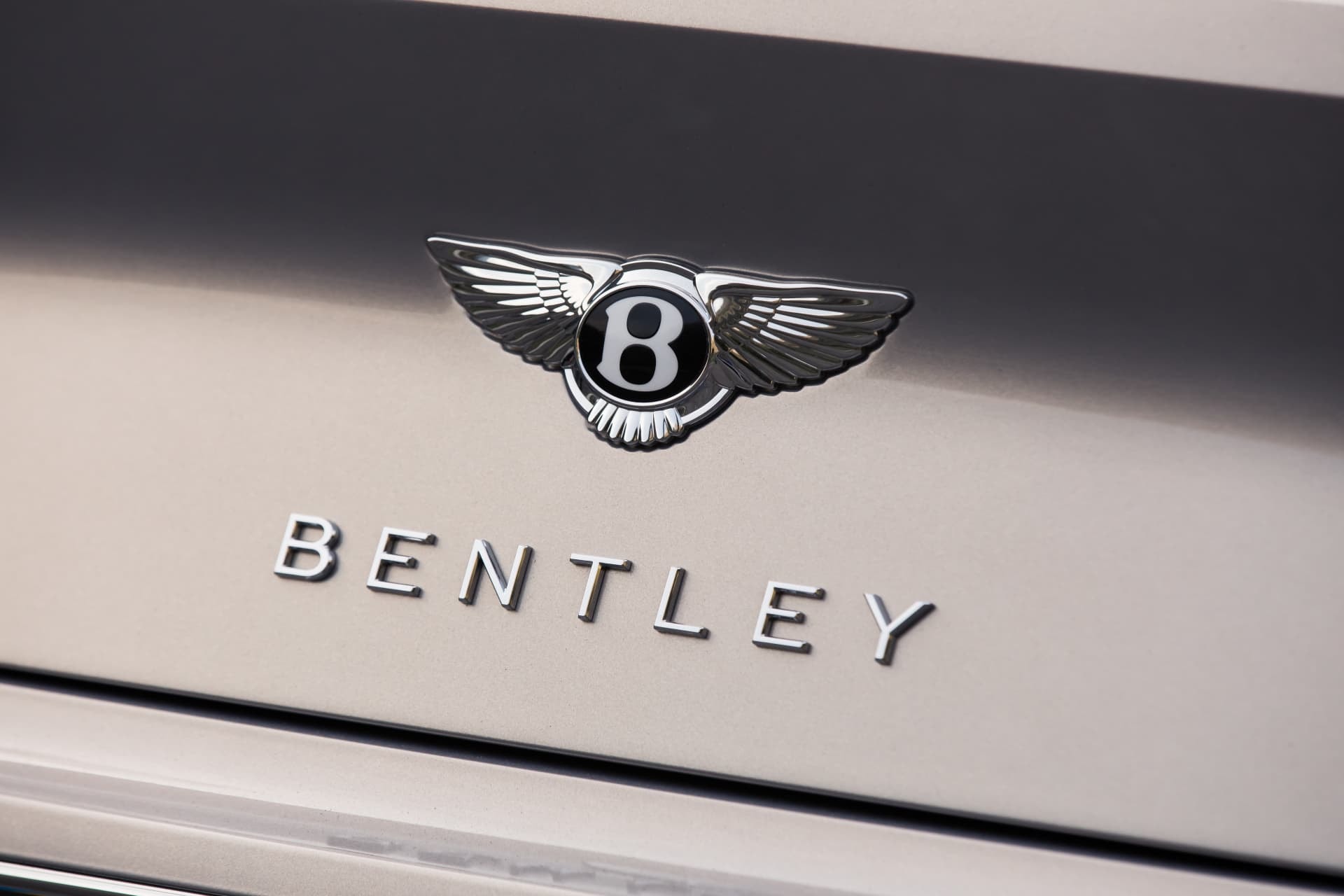 Enfoque en el emblema 'Bentley' y número '8' montados sobre el acabado cromado.