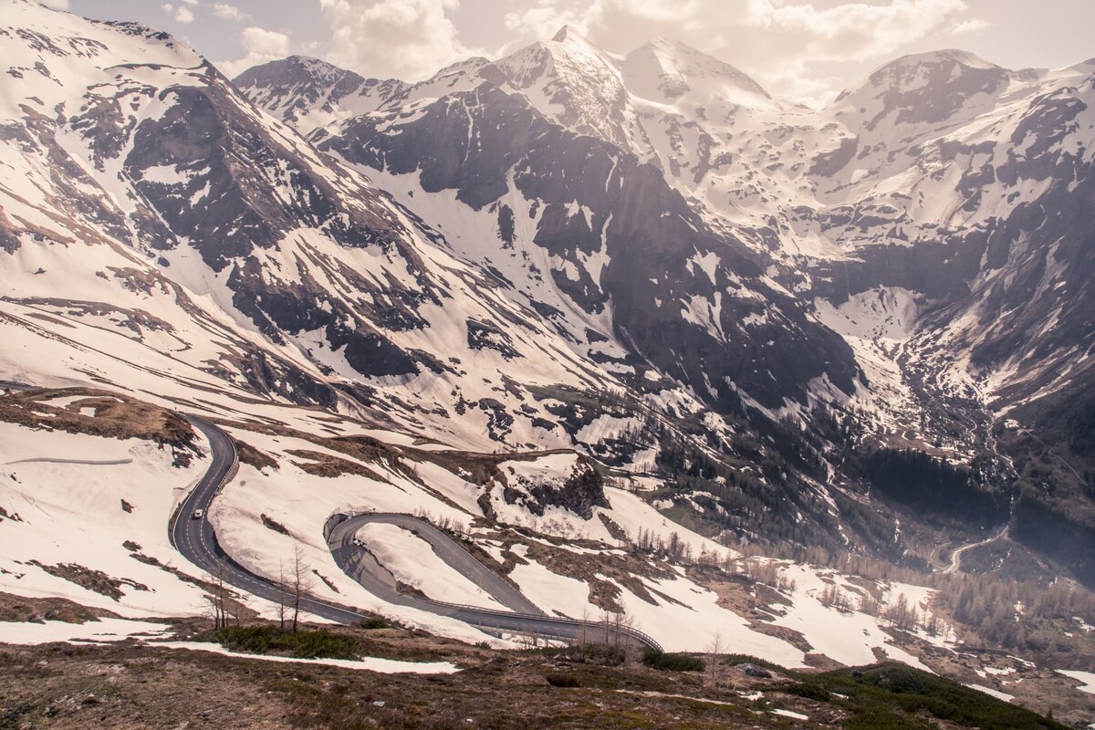 El Bentley Continental GT toma una curva con montañas nevadas de fondo. El Bentley Continental GT toma una curva con montañas nevadas de fondo.
