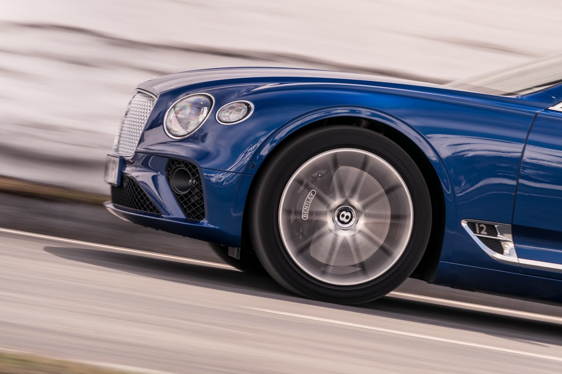 Detalle dinámico de la llanta y carrocería del Bentley Continental GT.
