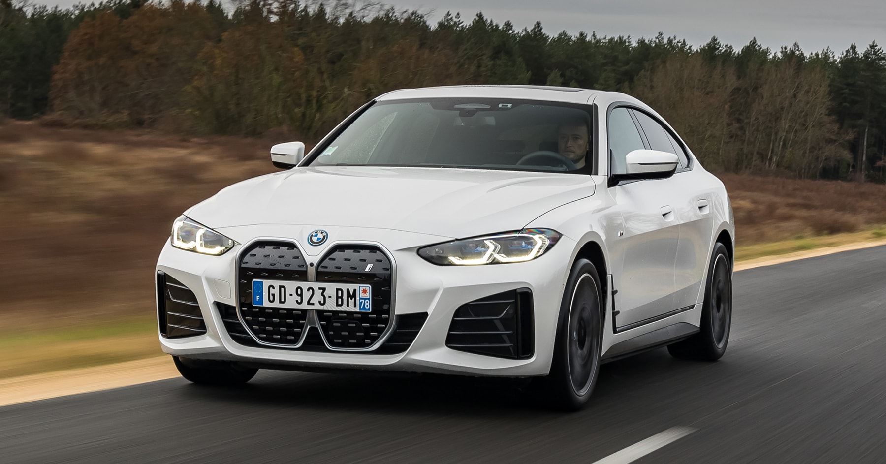 Vista dinámica del BMW i4, destaca su frontal agresivo y línea lateral fluida.