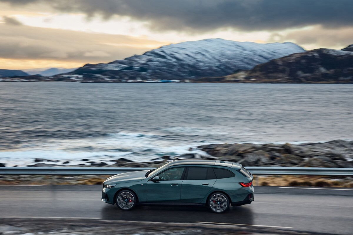 Perfil del BMW i5 Touring en un entorno montañoso, resaltando su elegancia. Perfil del BMW i5 Touring en un entorno montañoso, resaltando su elegancia.
