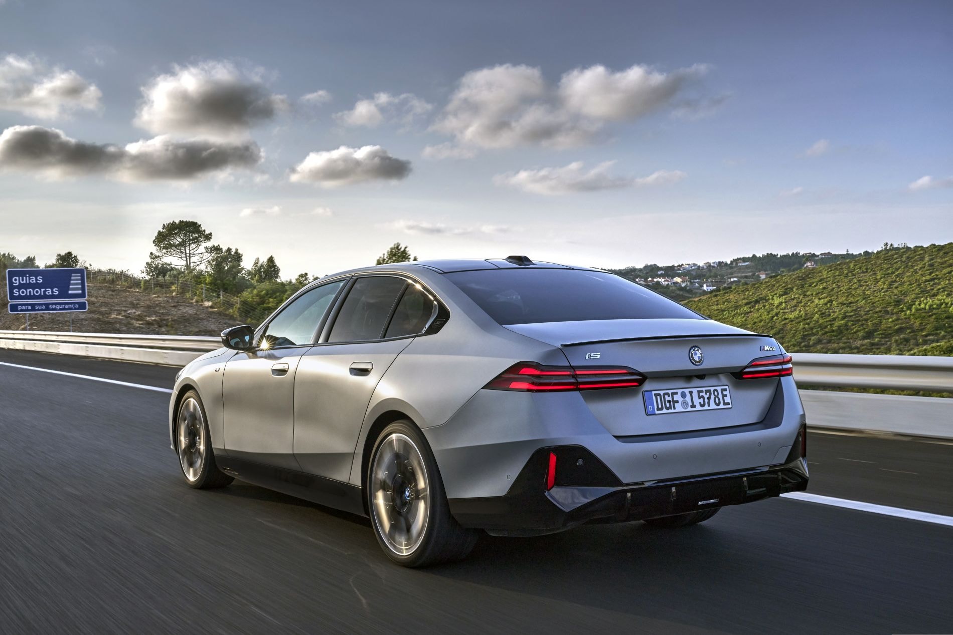 Vista dinámica del BMW i5 en carretera, resaltando su diseño elegante.