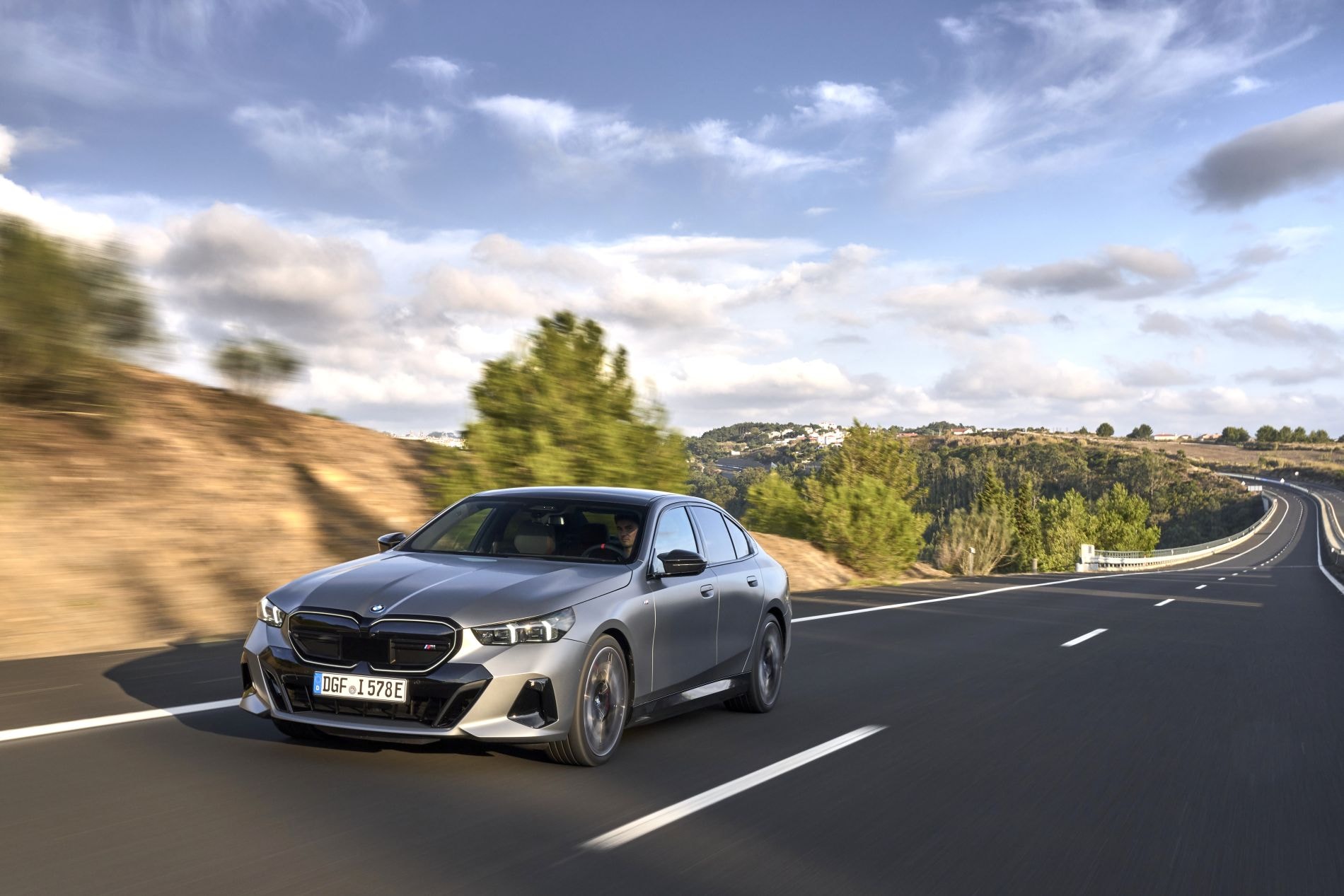 El BMW i5 muestra su elegante diseño mientras circula por carretera. Perfecto equilibrio entre estilo y rendimiento.