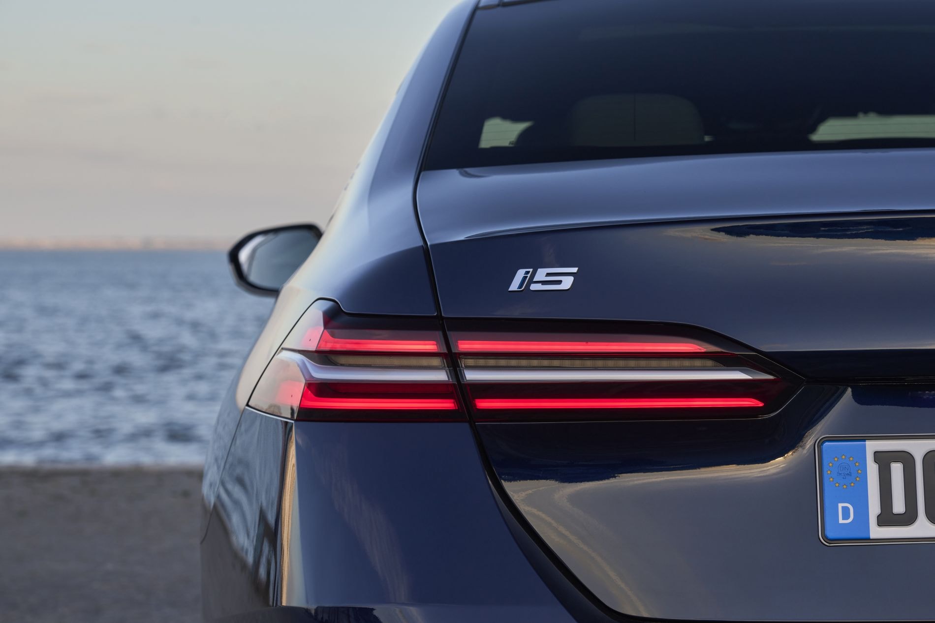 Vista frontal del BMW i5 en una curva, destacando su imponente parrilla.