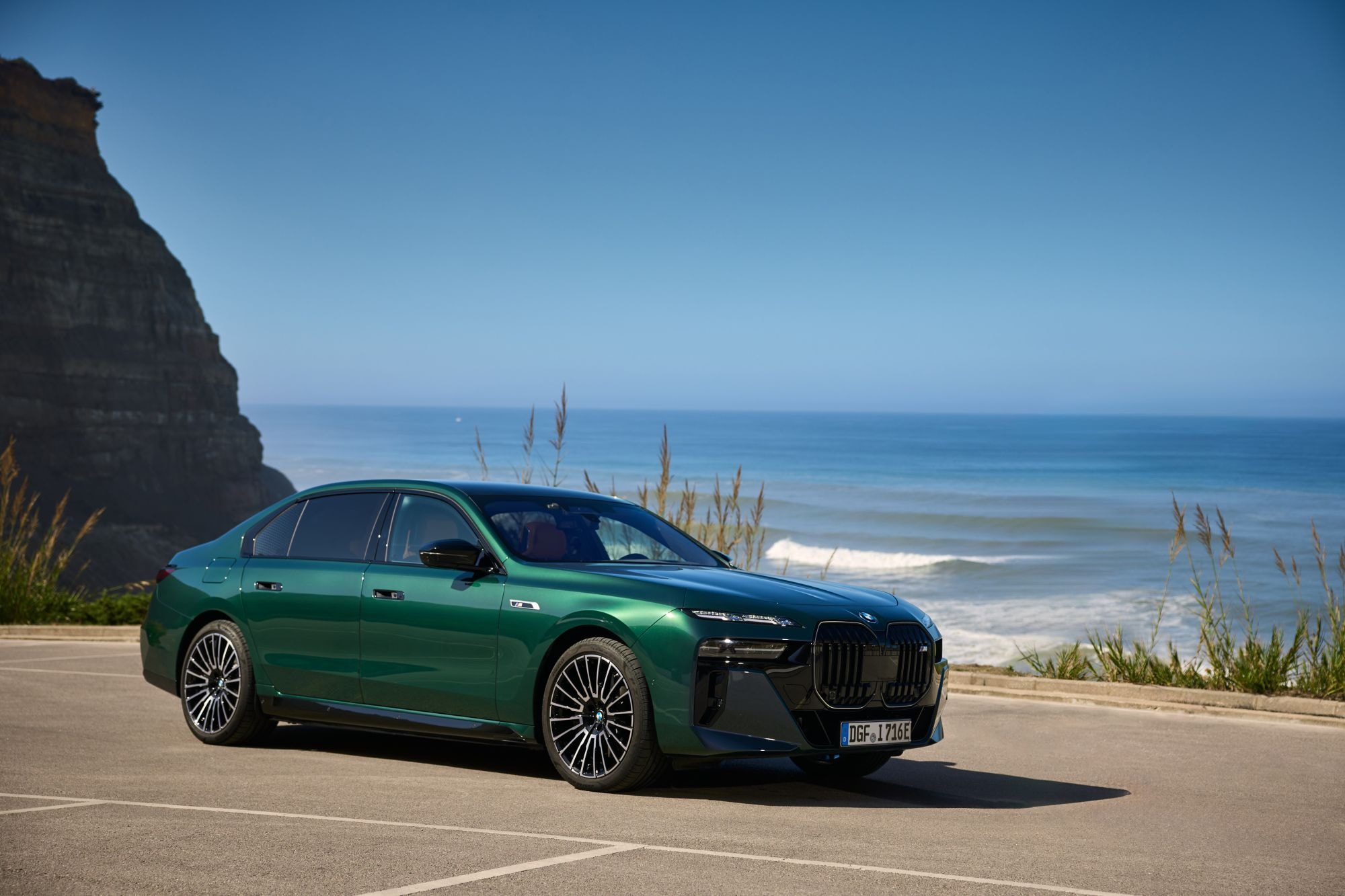 Vista trasera del BMW i7 eléctrico en un ambiente costero.