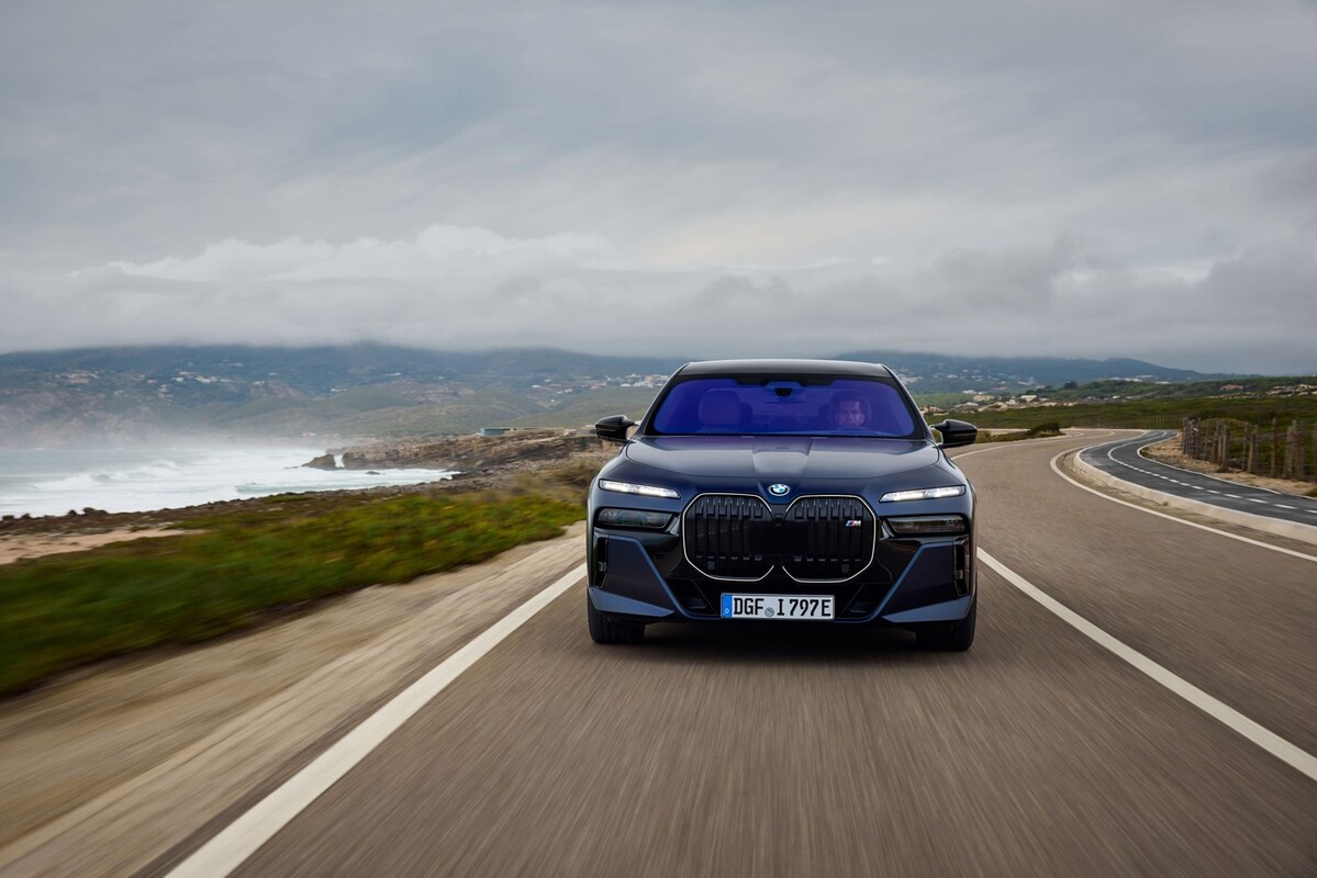 BMW i7 estacionado con un puente emblemático de fondo. BMW i7 estacionado con un puente emblemático de fondo.