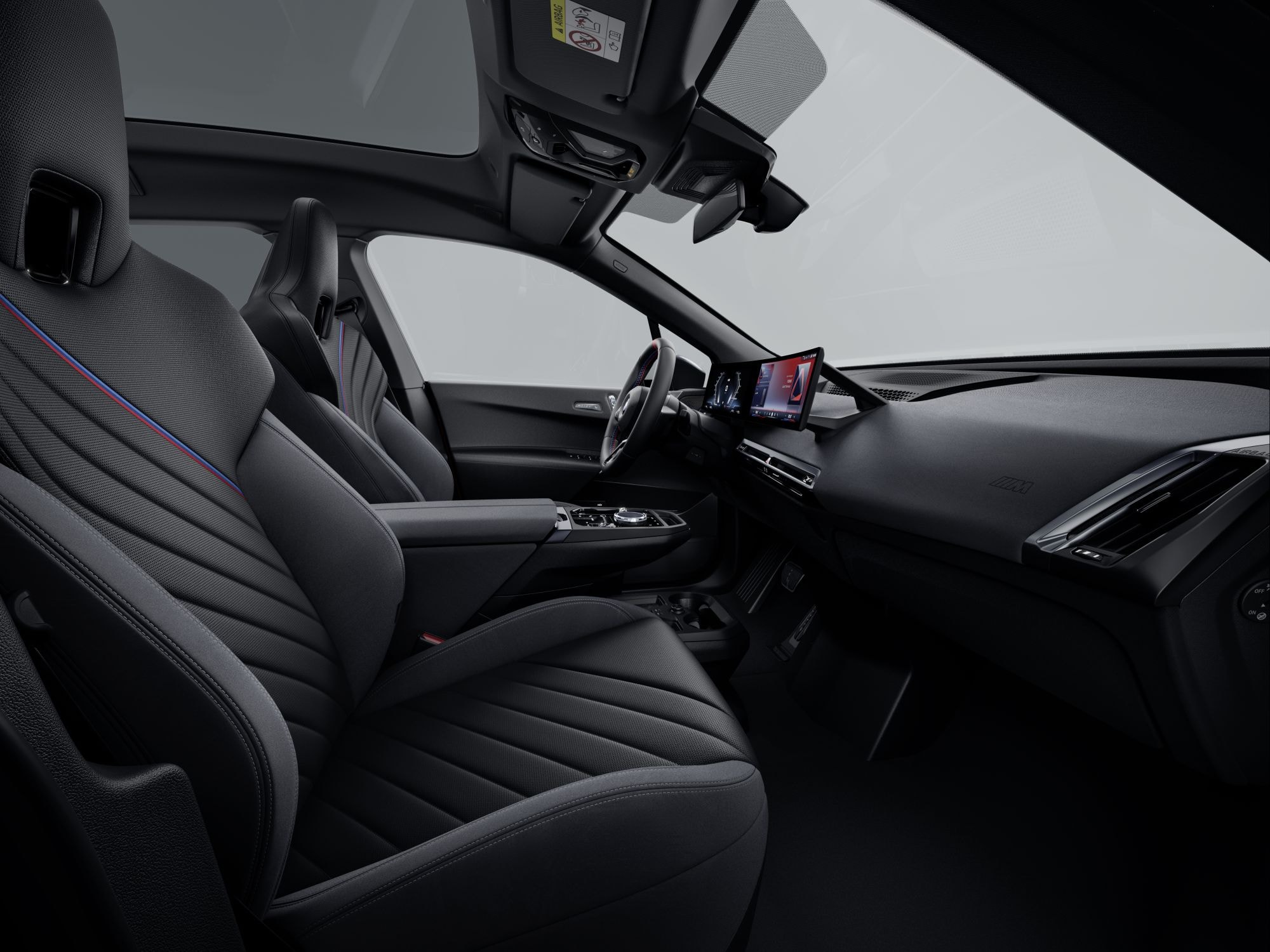 Interior del BMW iX con un techo panorámico y asientos deportivos.