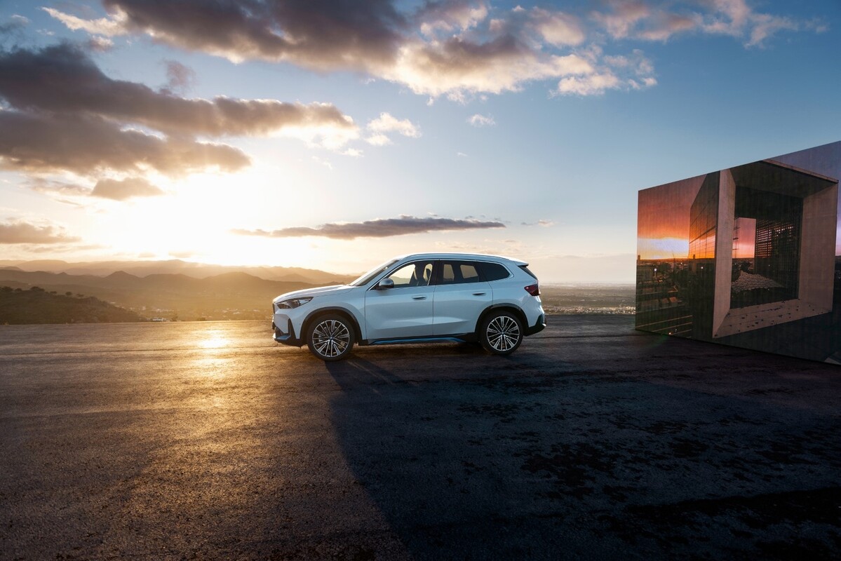Vista lateral del BMW iX1 eléctrico capturada en condiciones de atardecer. Vista lateral del BMW iX1 eléctrico capturada en condiciones de atardecer.