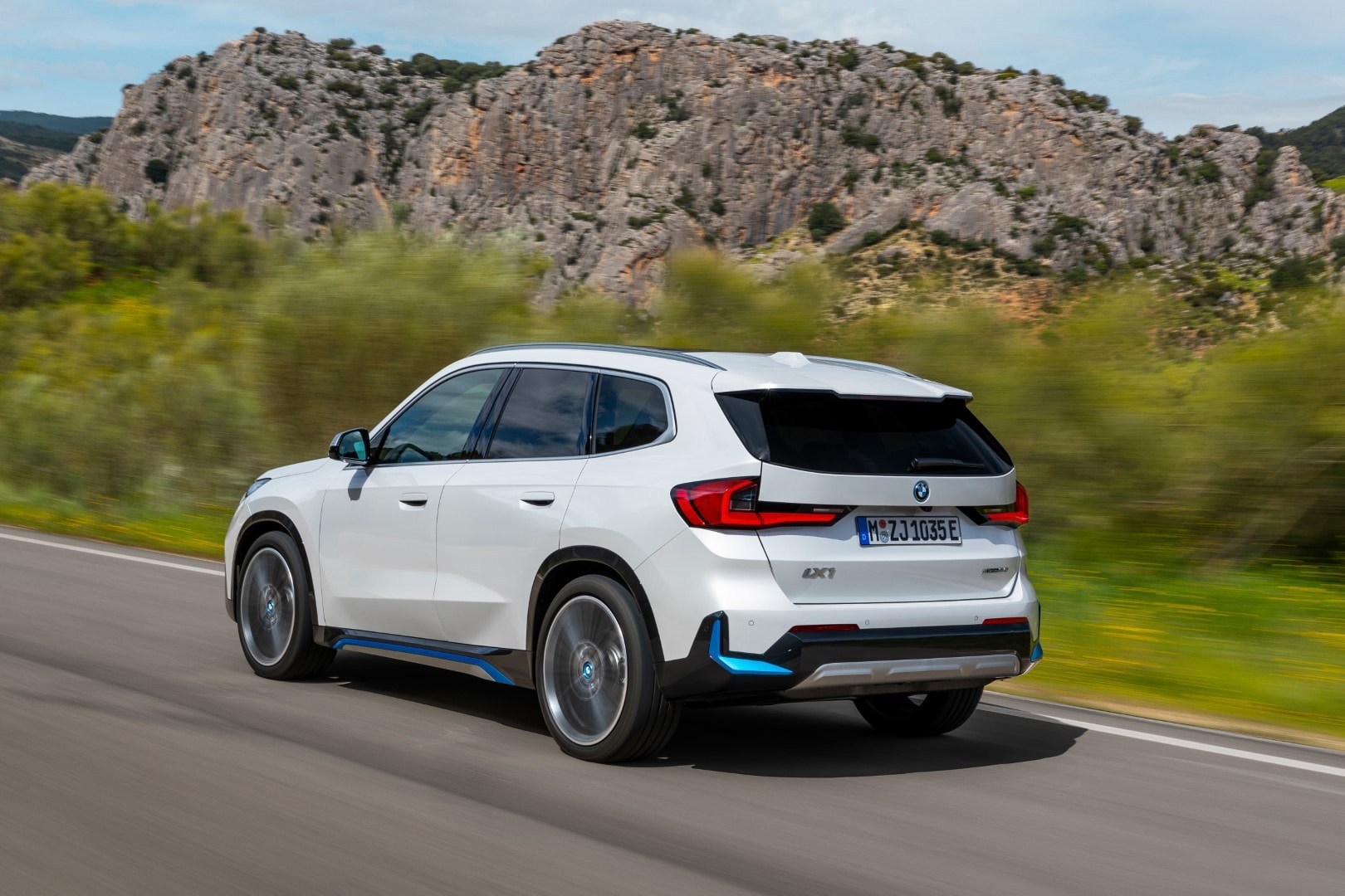 Trasera del BMW iX1 eléctrico mostrando su dinamismo en carretera.