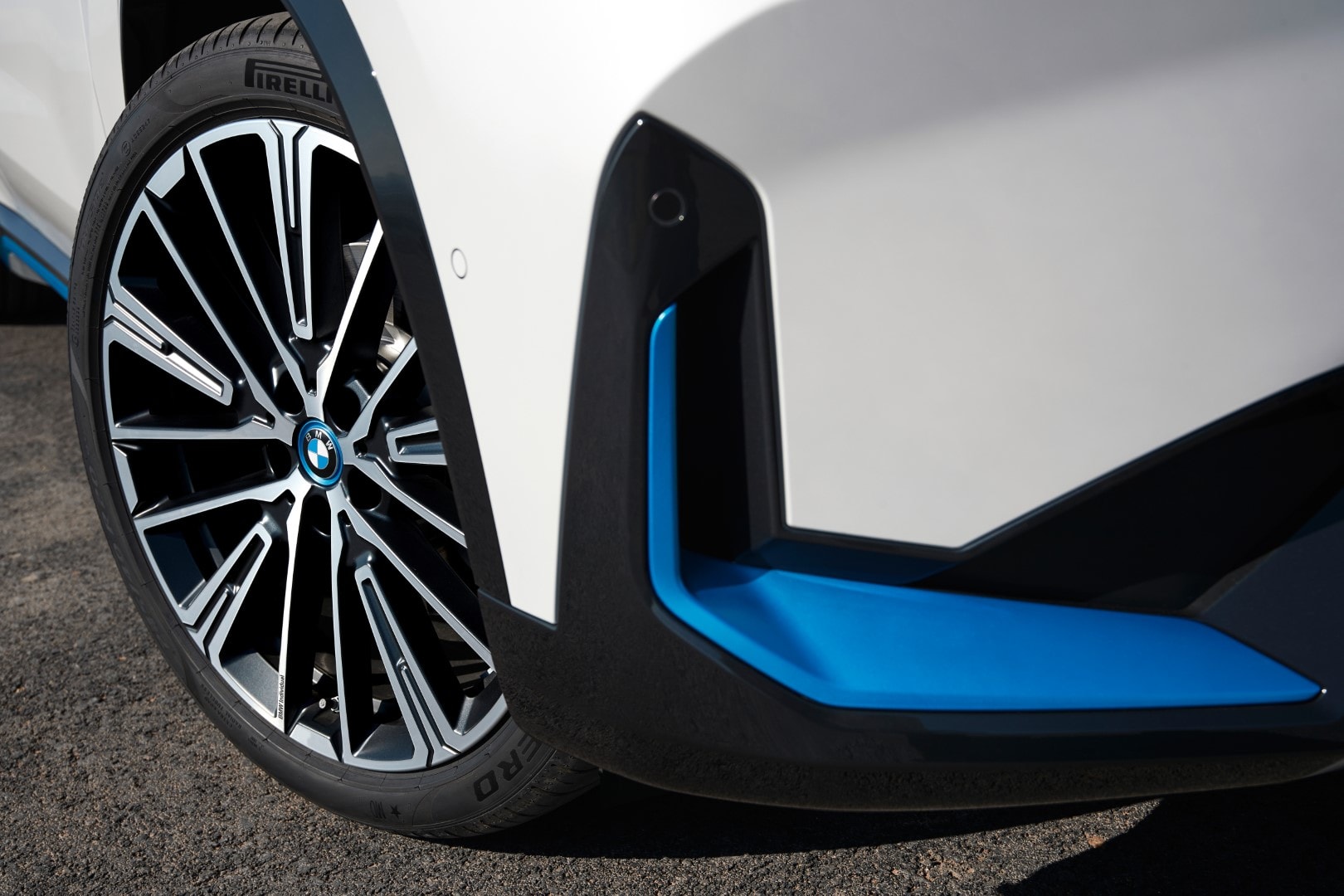 Primer plano del detalle de la llanta y diseño del faldón del BMW iX1 eléctrico.