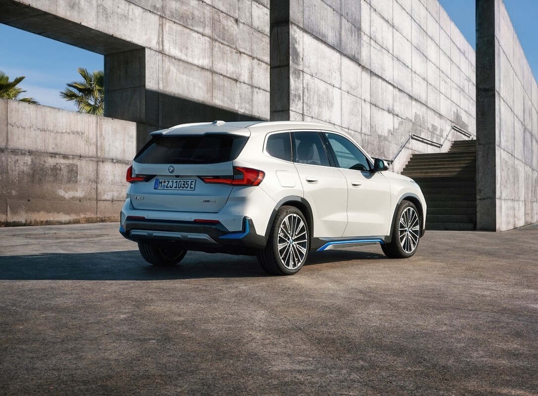 Vista trasera y lateral del BMW iX1 destacando su diseño moderno. Vista trasera y lateral del BMW iX1 destacando su diseño moderno.
