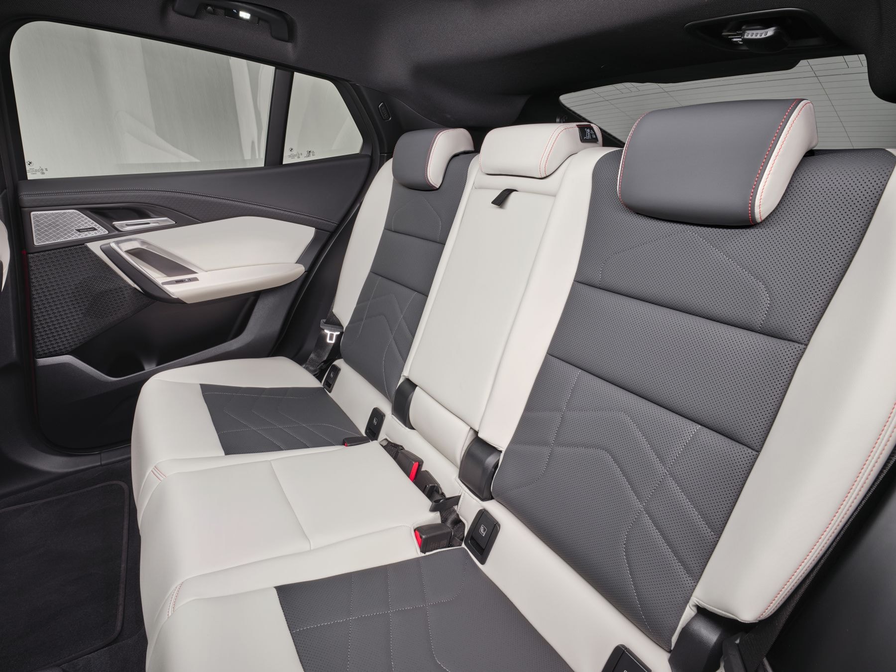Vista del interior trasero del BMW iX2, con asientos cómodos y modernos.