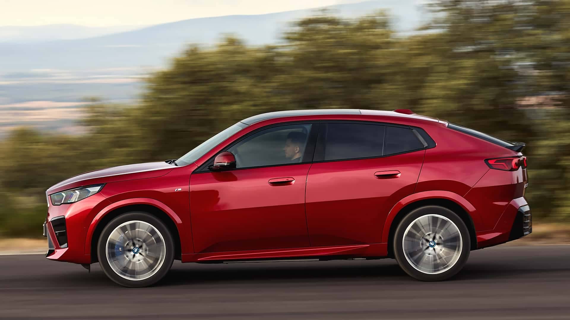 Perfil dinámico del BMW iX2 en carretera, mostrando su diseño lateral.