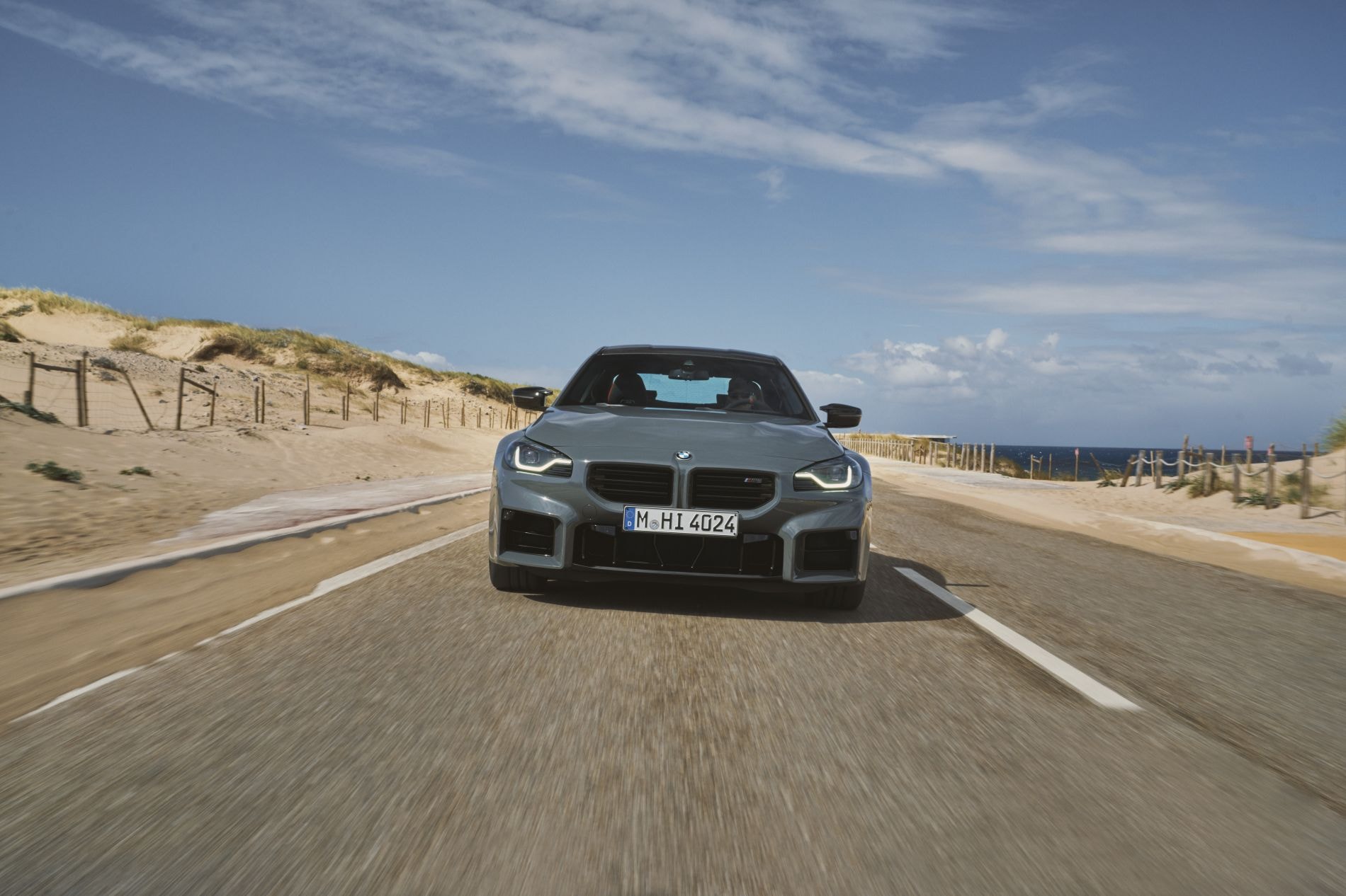 Otra perspectiva lateral del BMW M2, con un fondo panorámico espectacular.