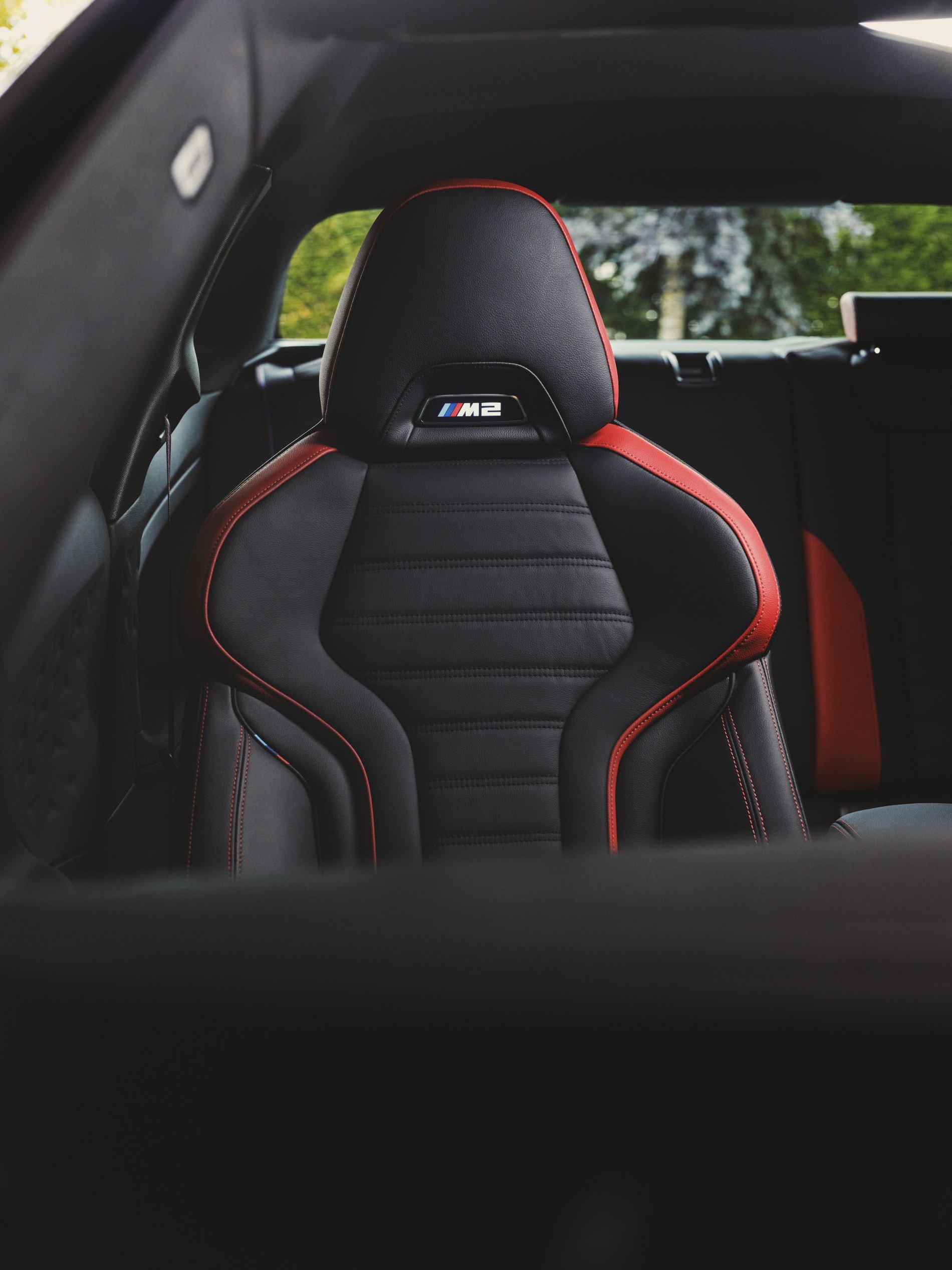 Vista lateral del BMW M2 en un pintoresco paseo costero.