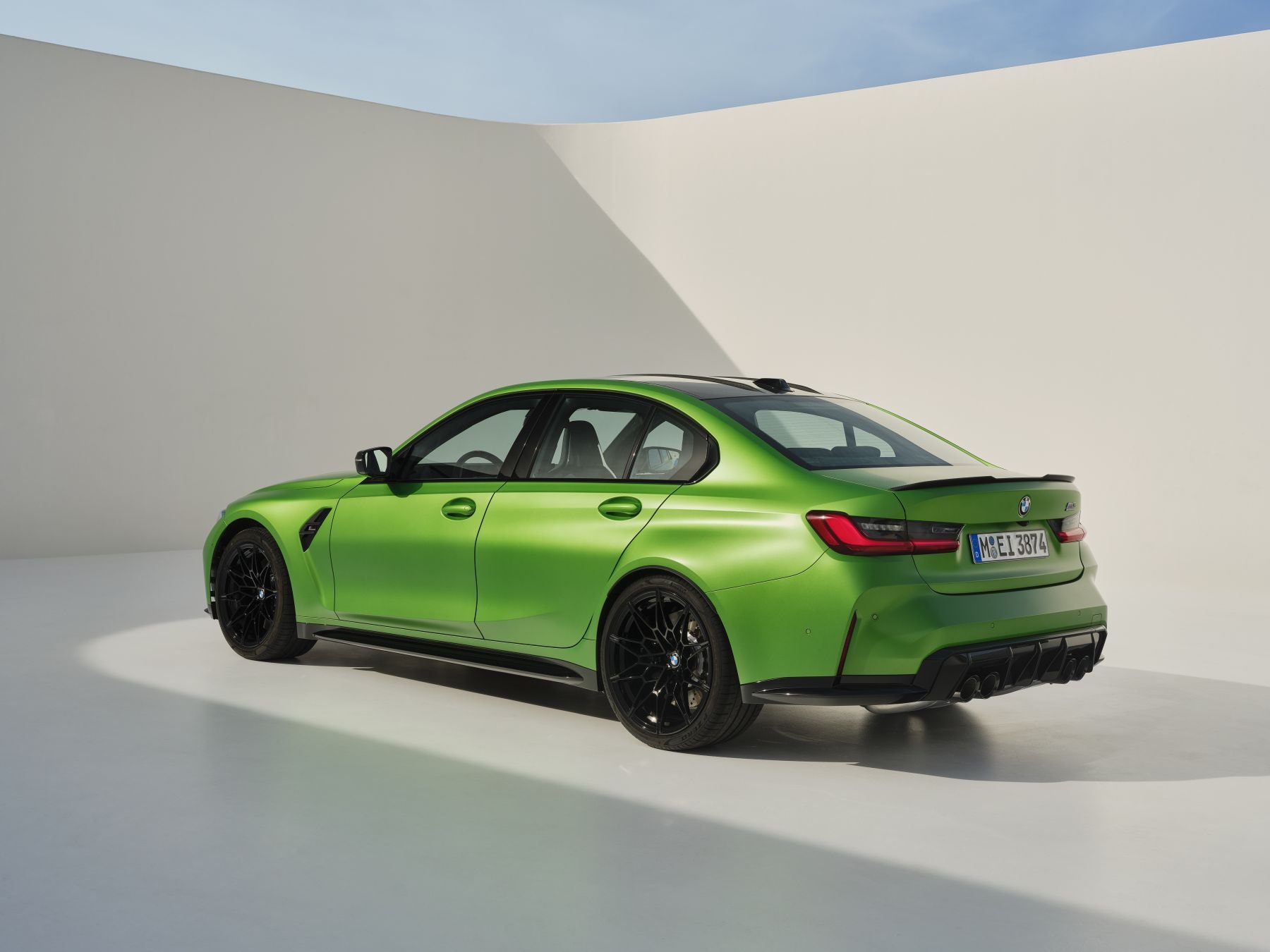 Vista lateral y trasera del BMW M3 en un impactante color verde. Un diseño aerodinámico que destaca.