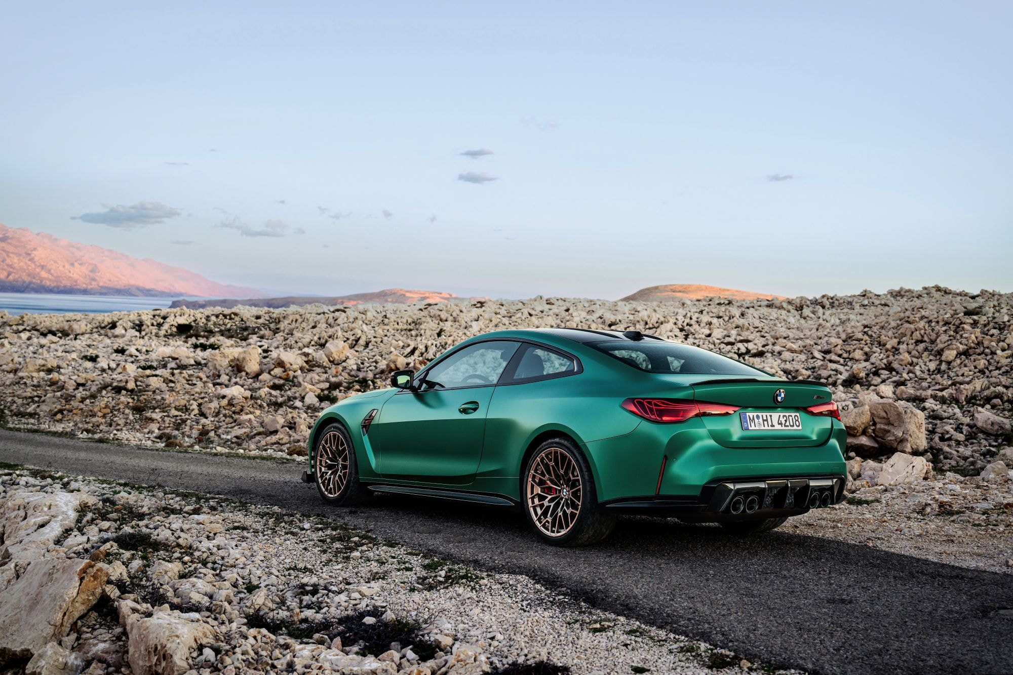 Presentación dinámica del M4 Coupé en un entorno costero, enfatizando su elegancia y deportividad.