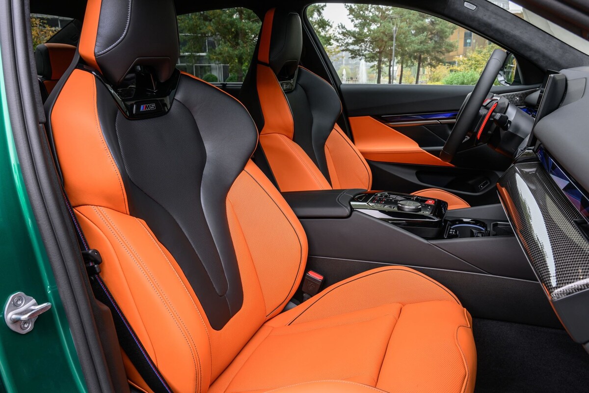 Interior del BMW M5 con asientos de cuero naranja, lujo y confort. Interior del BMW M5 con asientos de cuero naranja, lujo y confort.