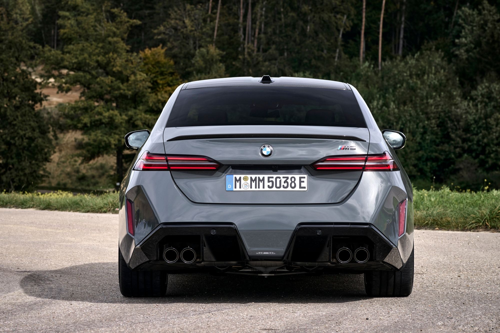 Vista trasera del BMW M5 en color verde, mostrando su agresivo diseño.