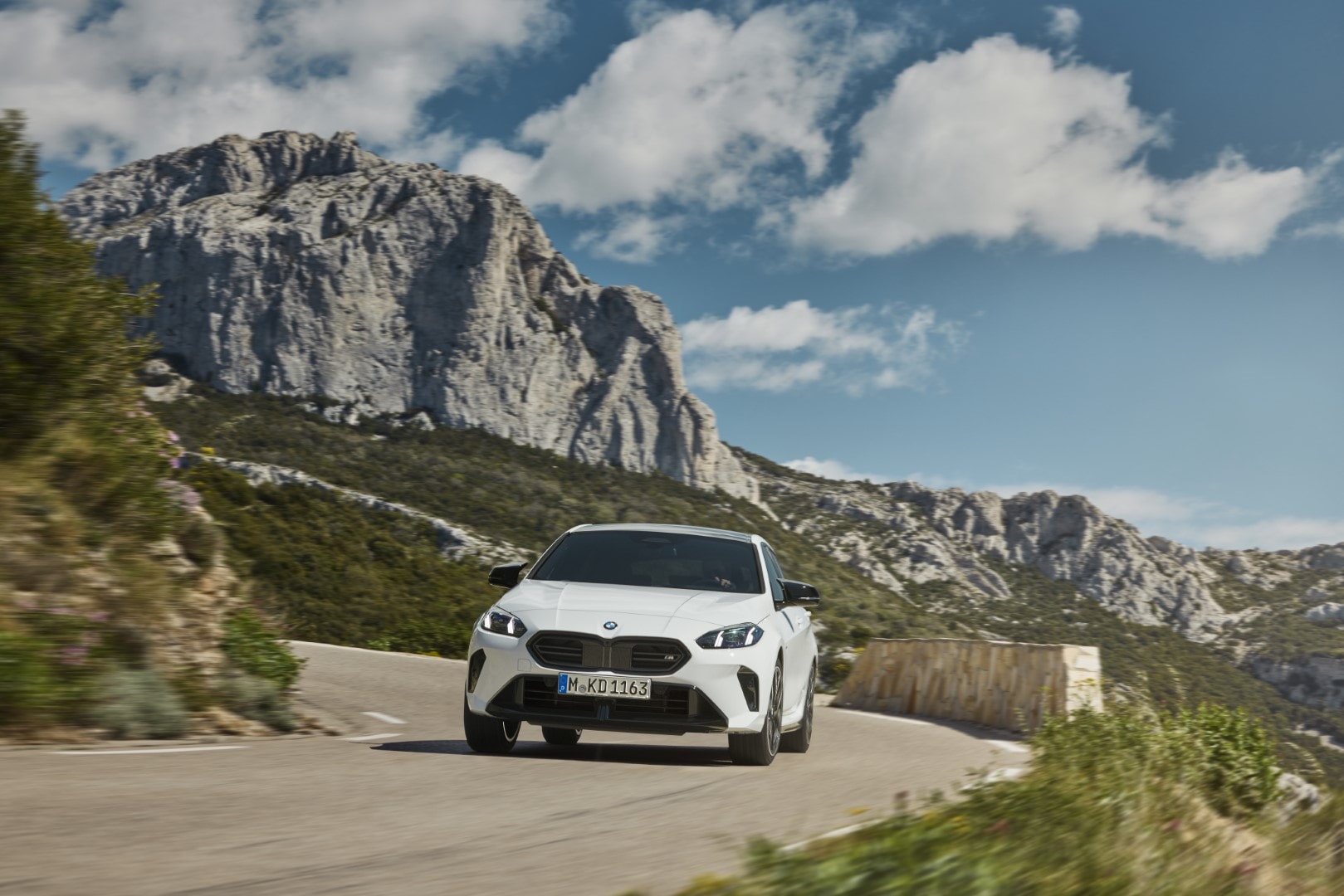 Vista frontal del BMW Serie 1 a velocidad, destacando el diseño de su parrilla y faros.