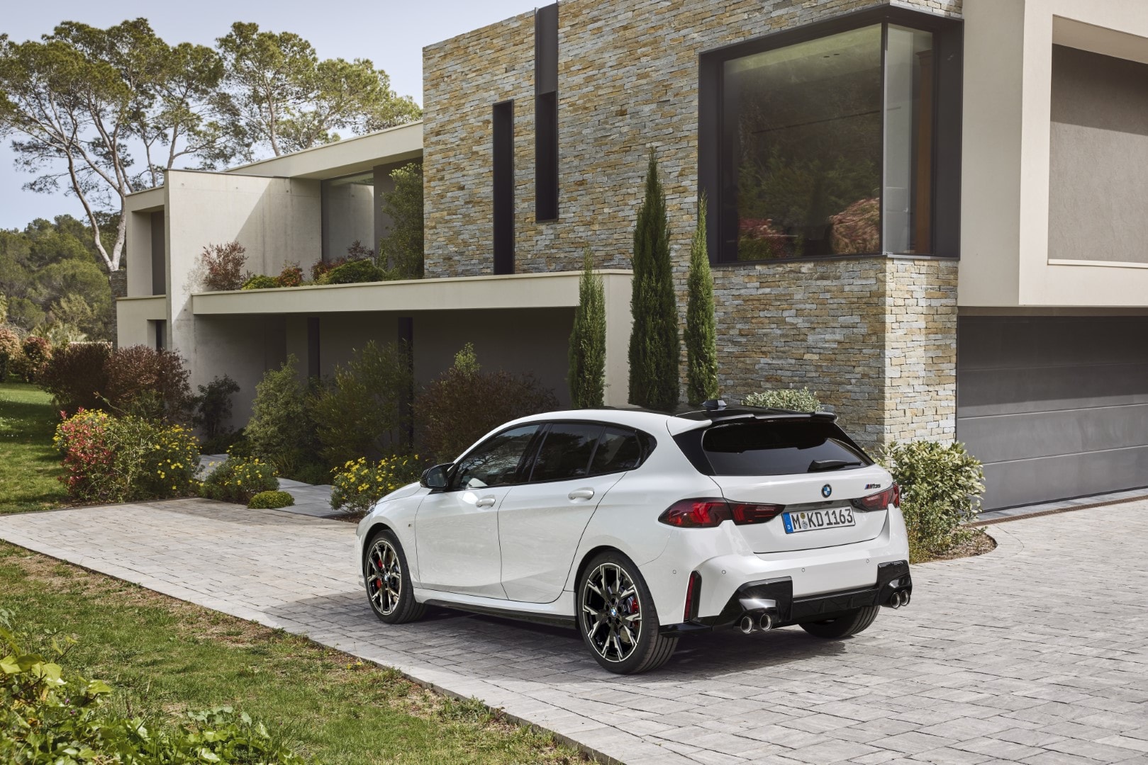 BMW Serie 1 mostrando su ángulo trasero y lateral en un entorno residencial.