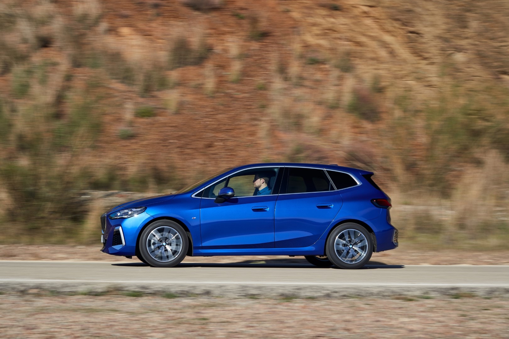 Lateral del BMW Serie 2 Active Tourer capturado en una carretera escénica.