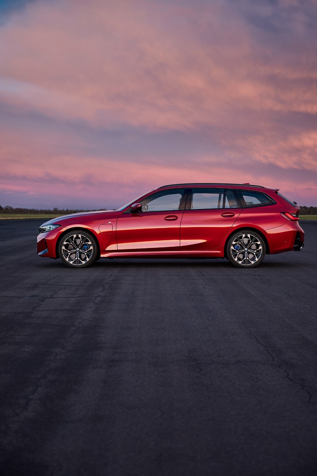 Lateral del BMW Serie 3 Touring bajo un cielo crepuscular, resonando con su estética dinámica.