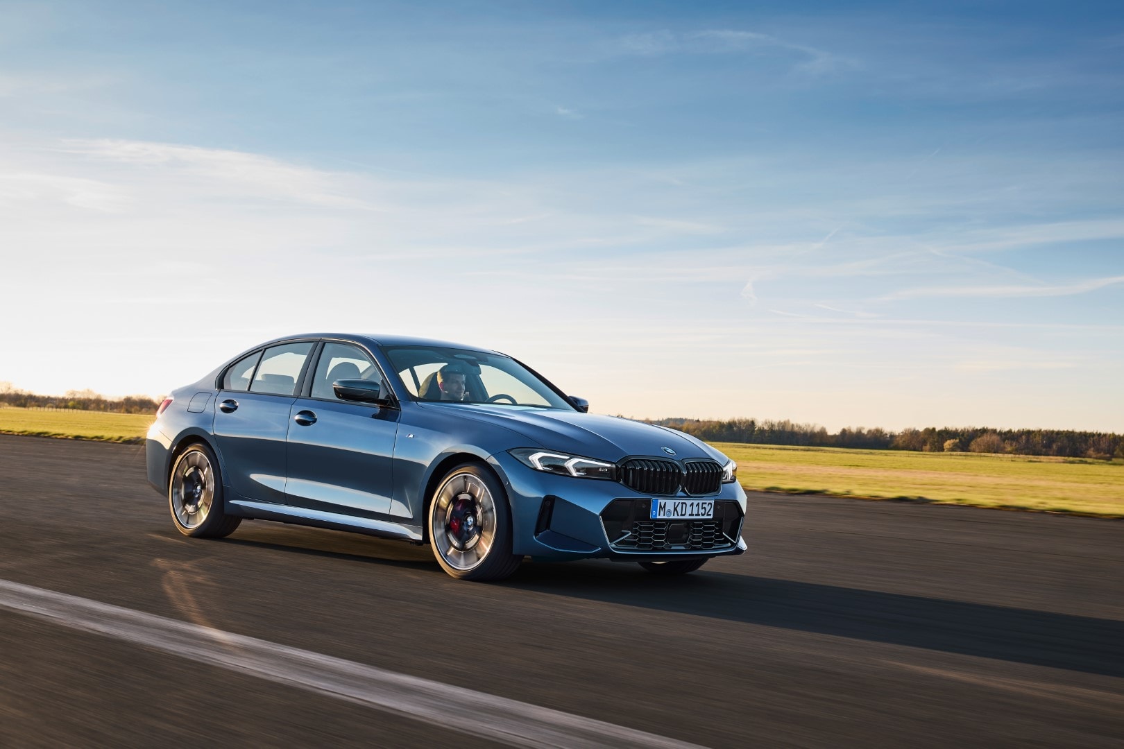 Perfil lateral del BMW Serie 3 en acción, resaltando su línea deportiva.