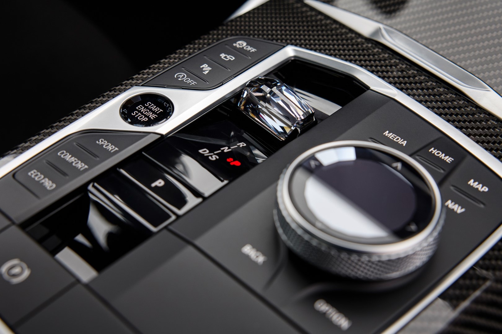 Vista detallada de la consola central del BMW Serie 3, mostrando el controlador iDrive y el cambio de marchas.