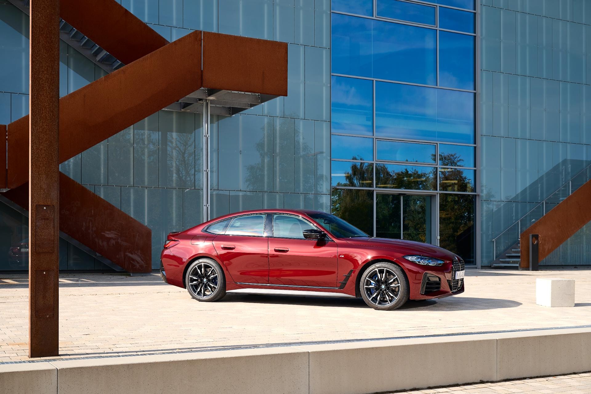 El BMW Serie 4 Gran Coupé aparcado frente a una estructura contemporánea.