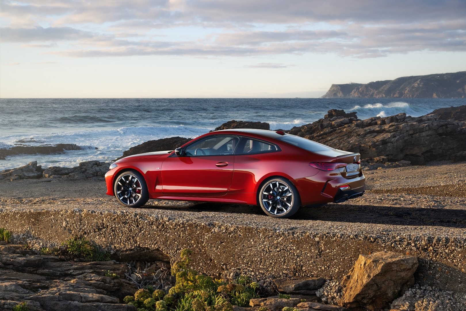 Vista lateral de un BMW Serie 4 en entorno natural, destacando su diseño dinámico.