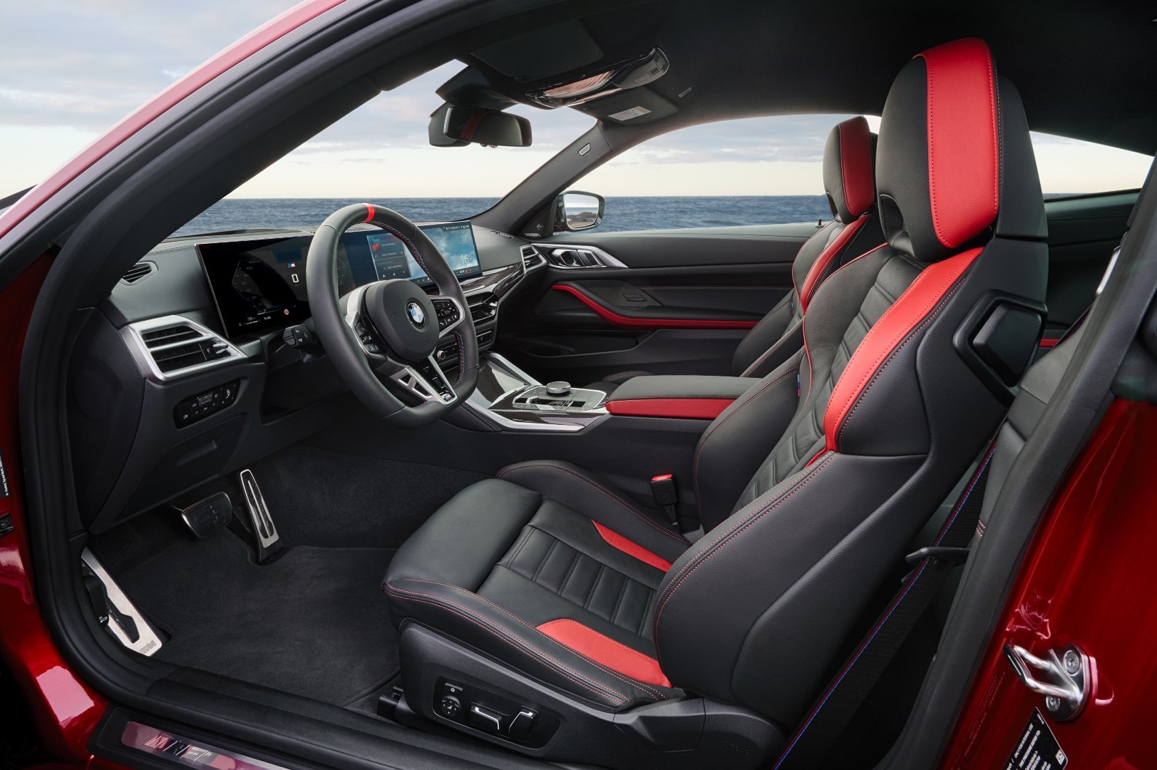 Interior con asientos deportivos en rojo y negro, destacando el confort y diseño.