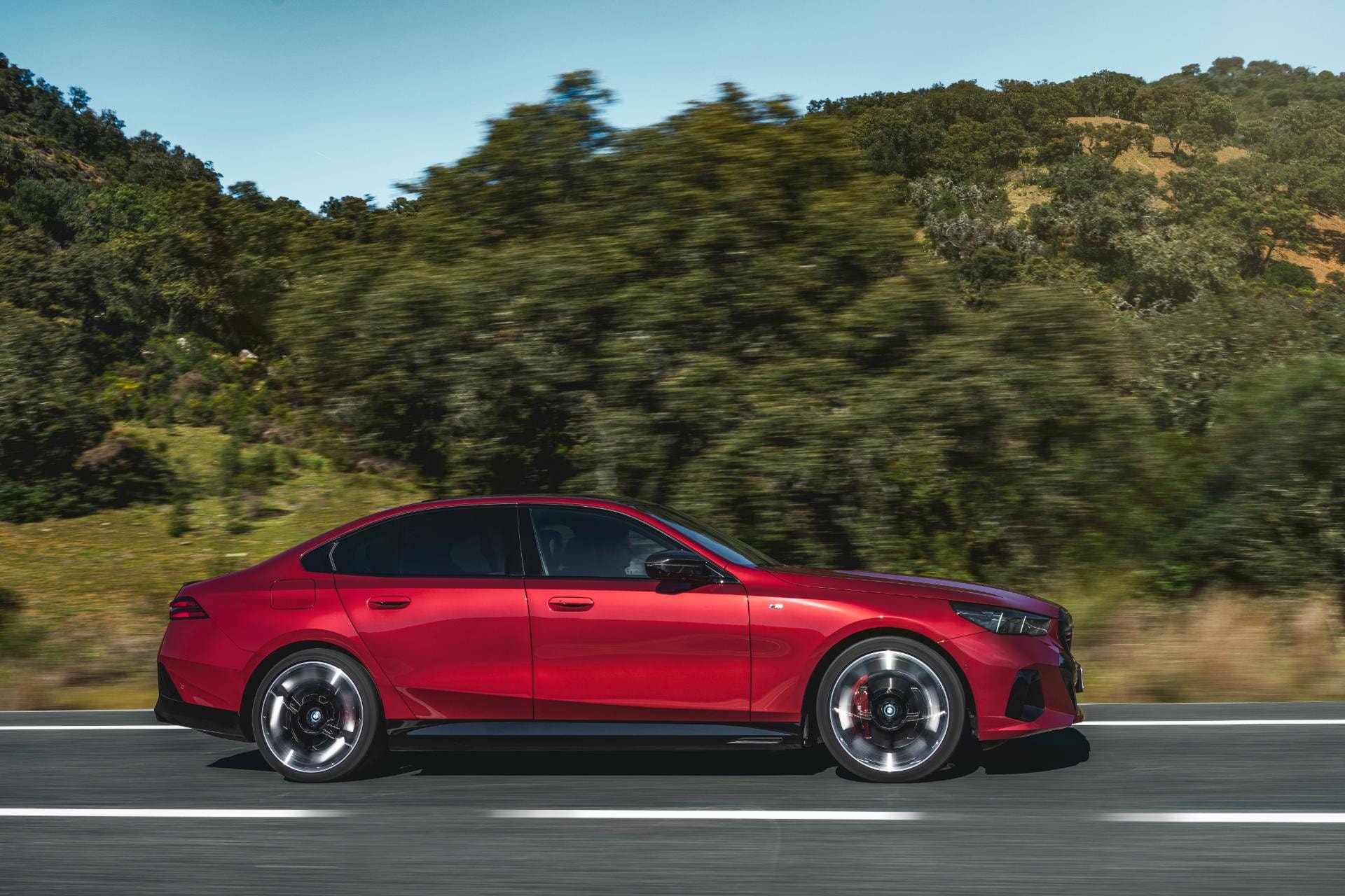 Vista lateral del BMW Serie 5 Híbrido conquistando la carretera de montaña.