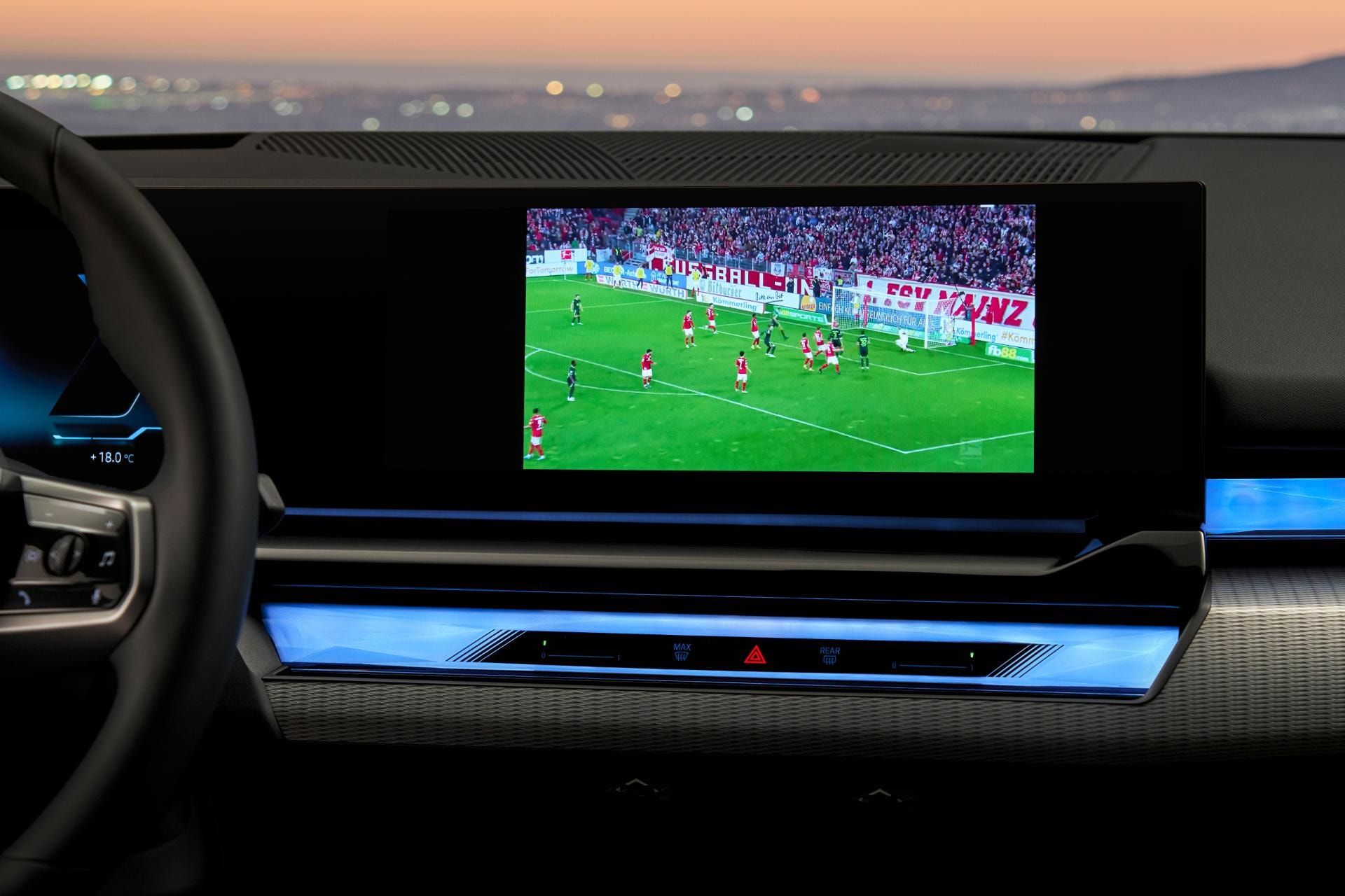 Pantalla central mostrando una transmisión deportiva, detalle tecnológico.