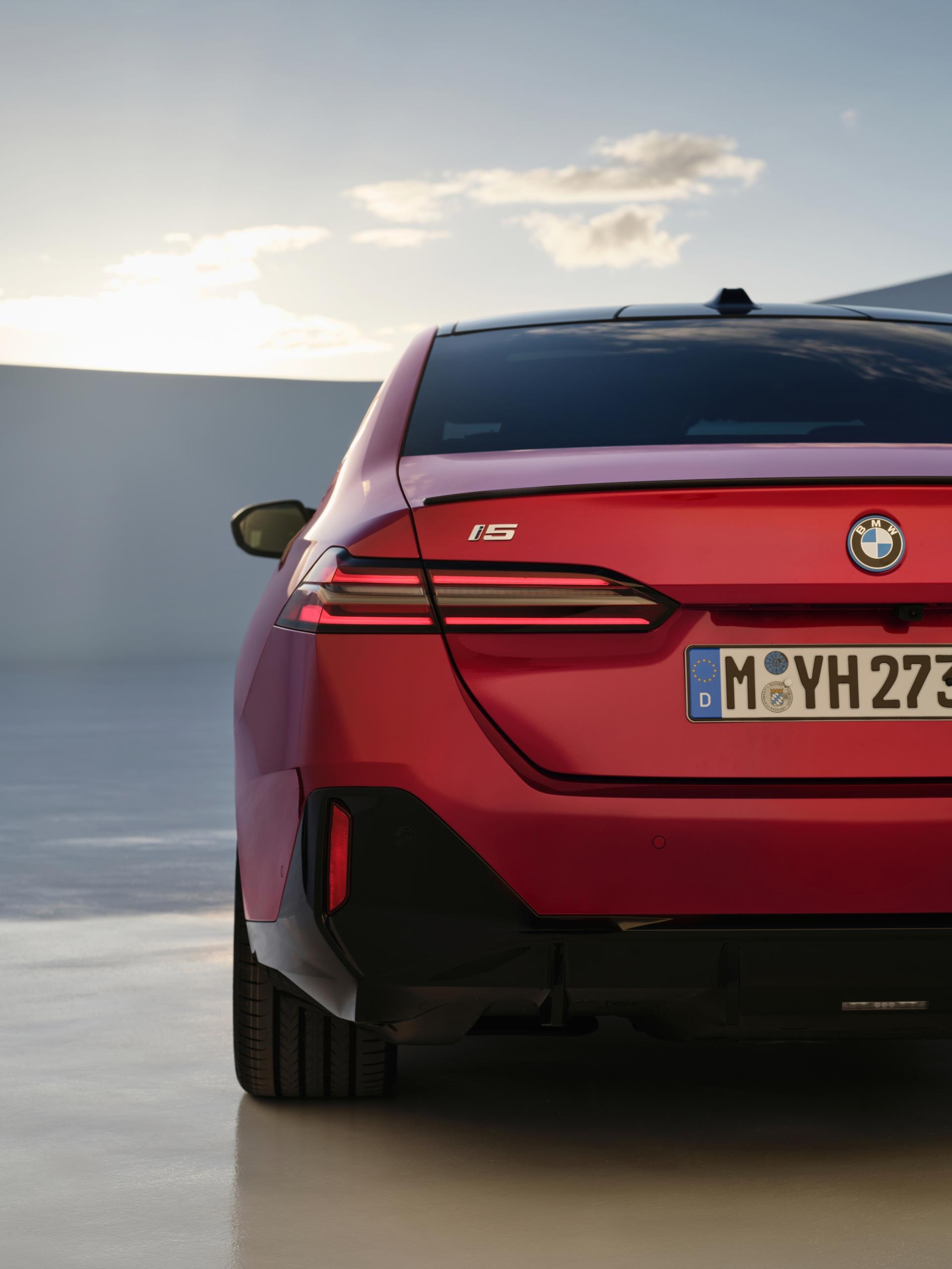 Trasera del BMW Serie 5 Híbrido en rojo capturada al atardecer.