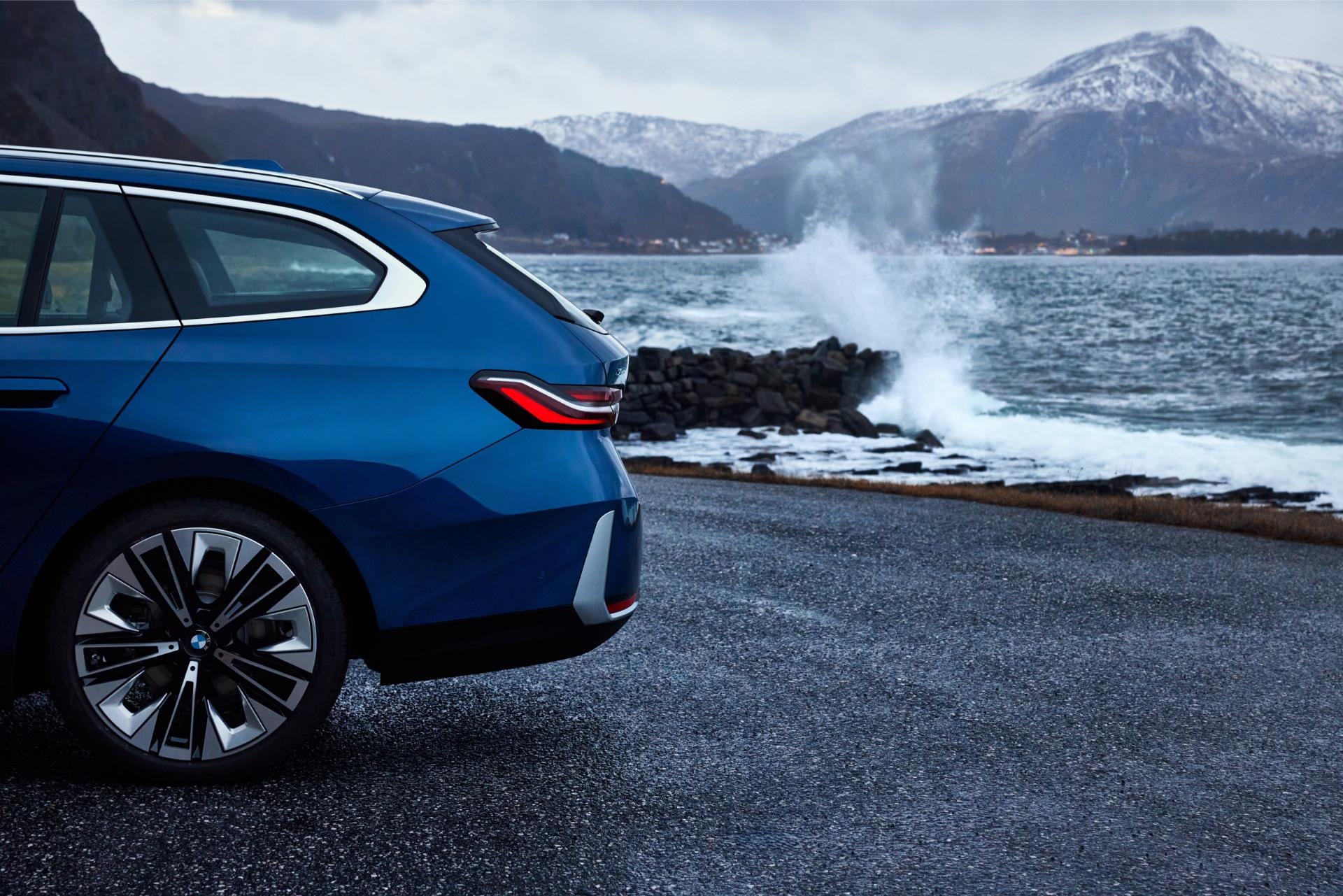 BMW Serie 5 Touring mostrando su silueta trasera y lateral en la costa.