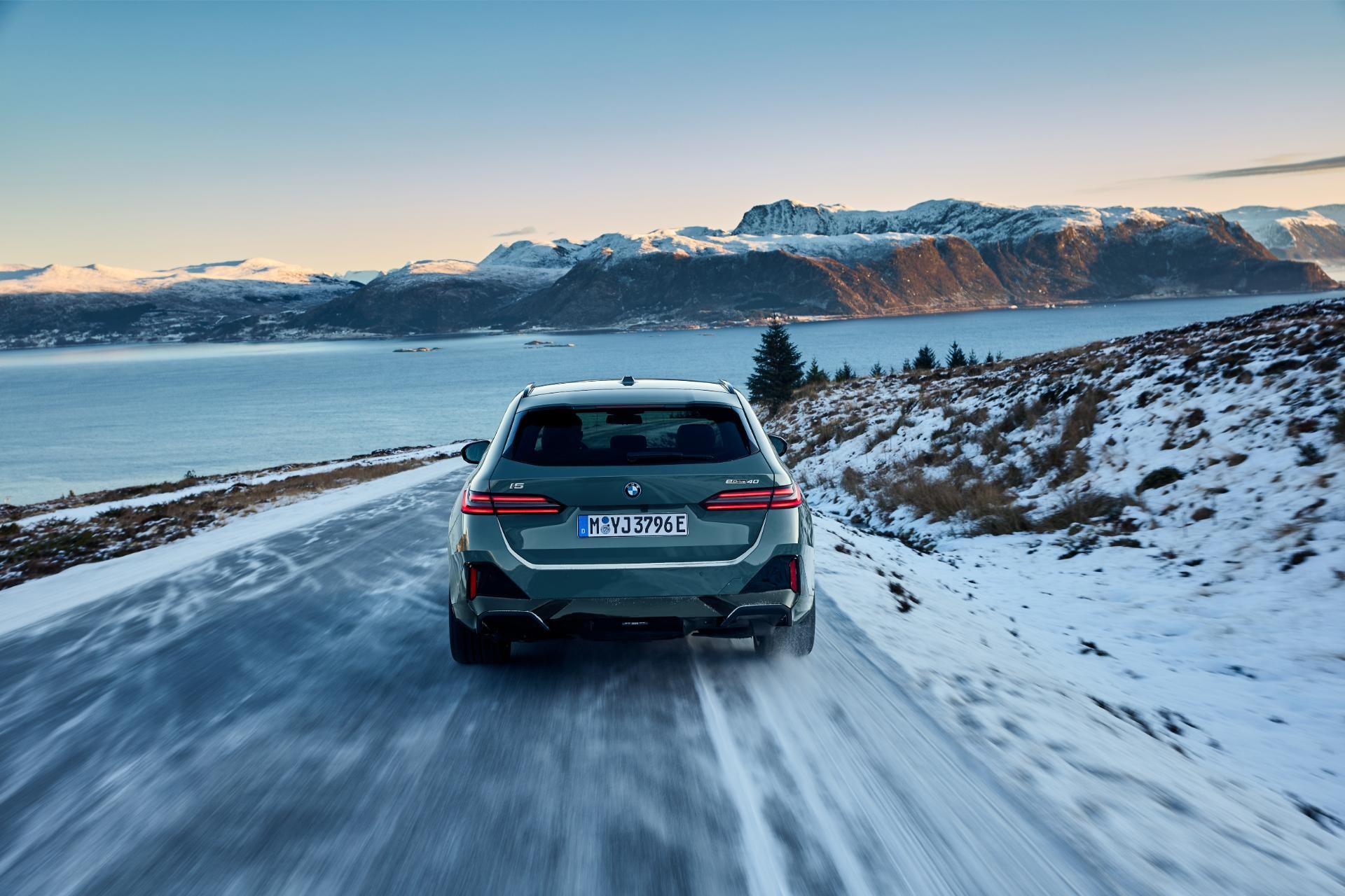 Vista trasera del BMW Serie 5 Touring sobre carretera nevada.