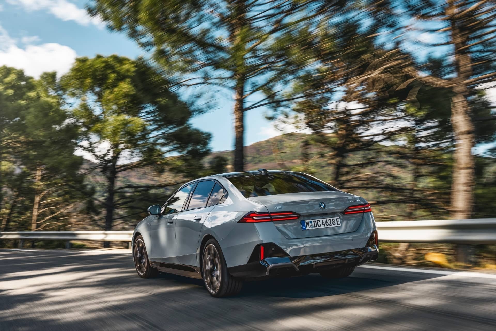 Vista dinámica del BMW Serie 5 en movimiento, trasera y lateral.