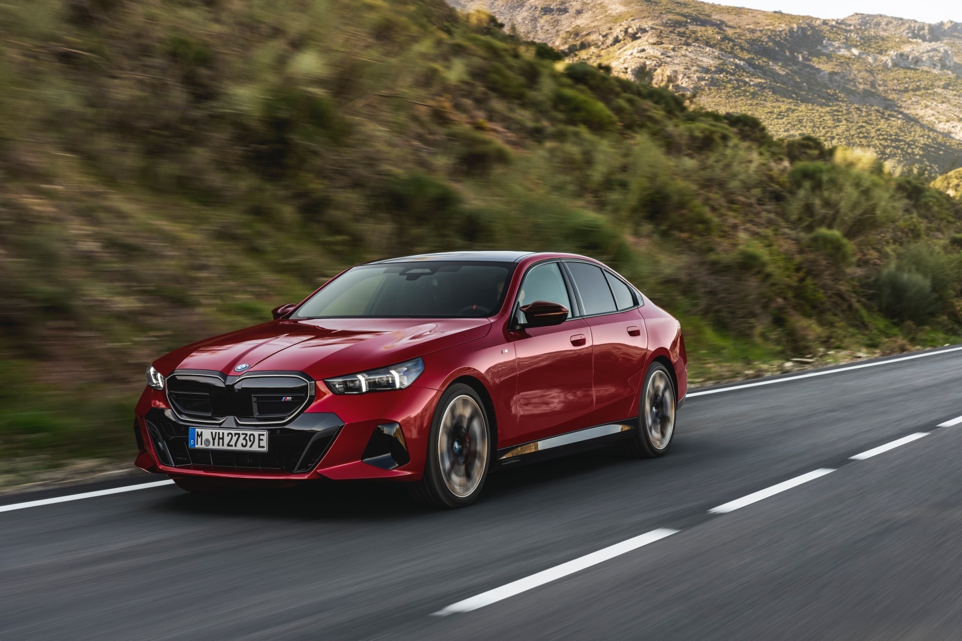 Vista dinámica del BMW Serie 5 rojo en carretera abierta.