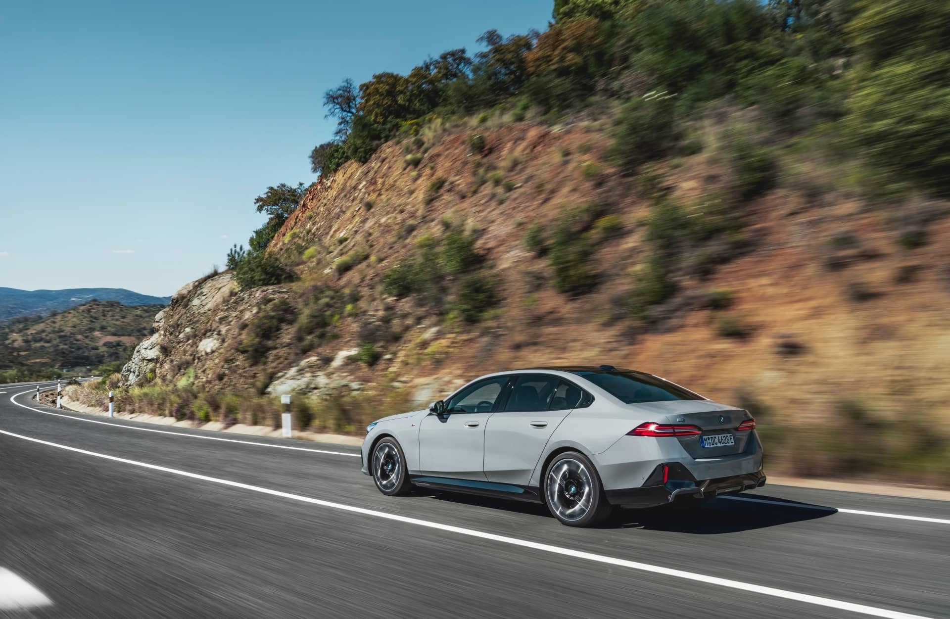 BMW Serie 5 mostrando su silueta trasera lateral en movimiento.