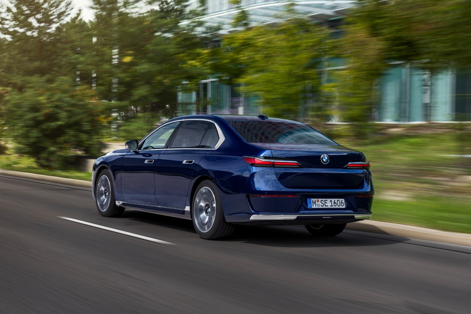 Visión trasera de un BMW Serie 7 Híbrido, destacando su diseño moderno al moverse.